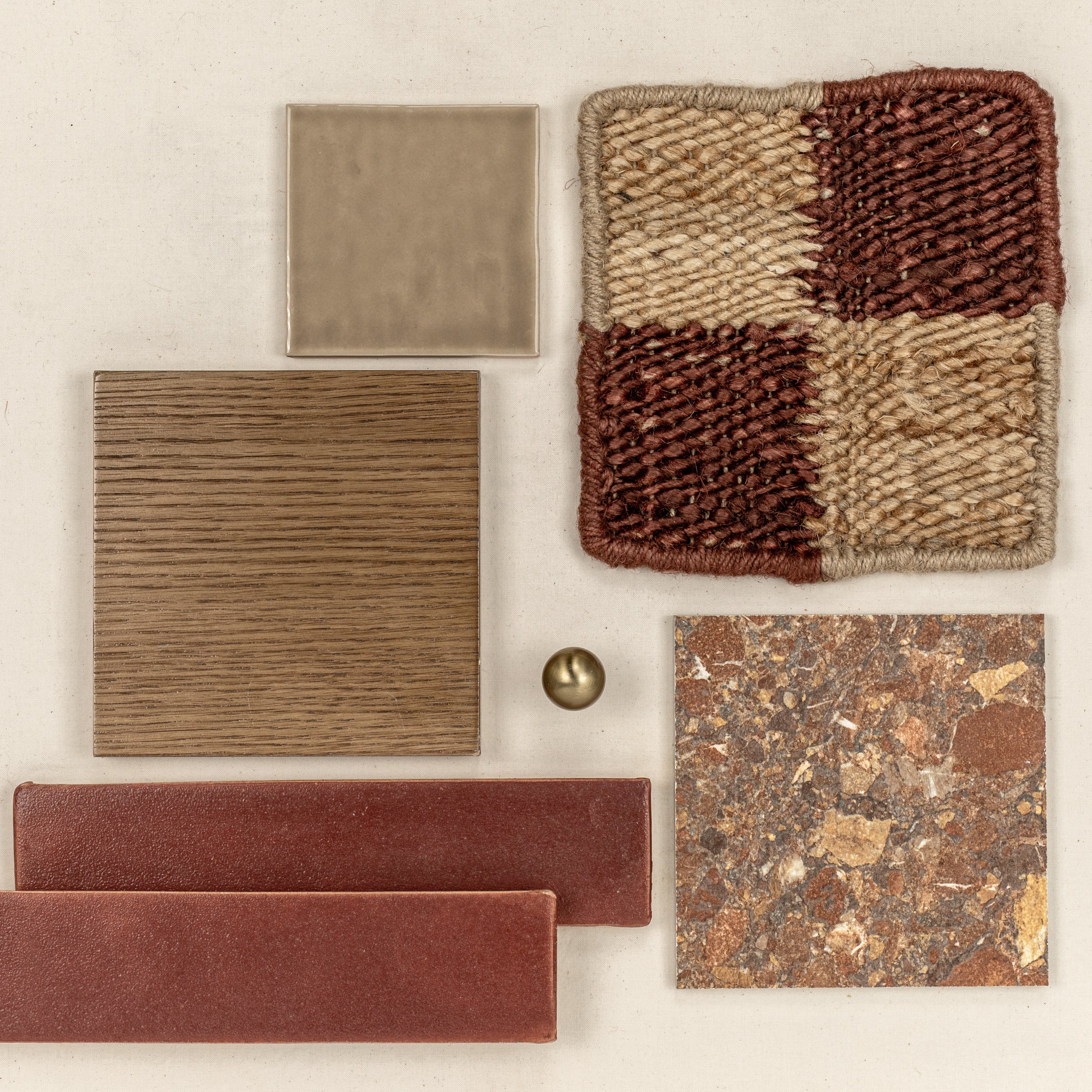 Square ceramic tiles in warm beige and brown tones paired with wood texture, rust-colored bricks, woven fabric, and a brass knob