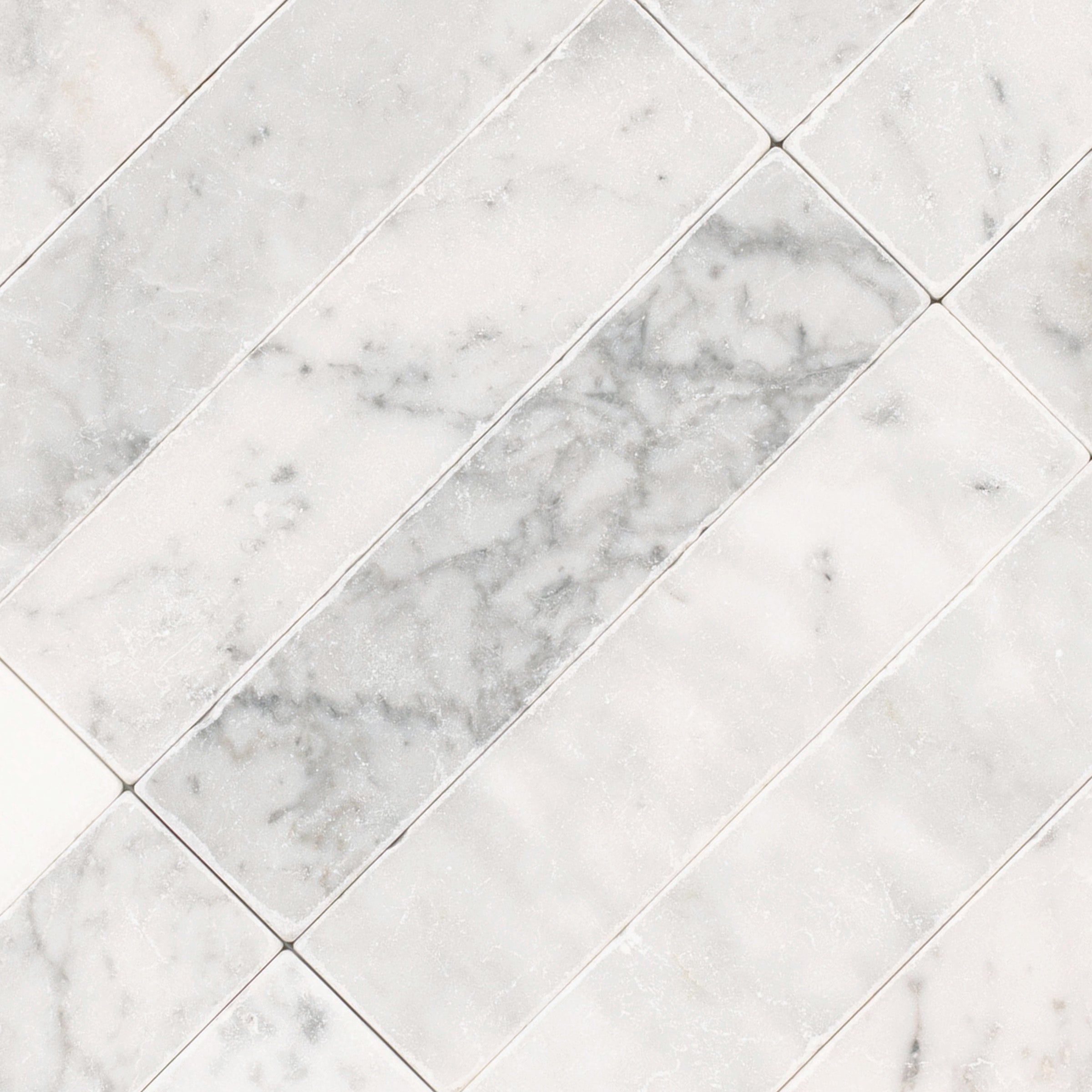 Carrara 2x8 Tumbled Marble Tile in gray and white tones from Tumbled Natural Stone Tiles Stone New Arrivals collection