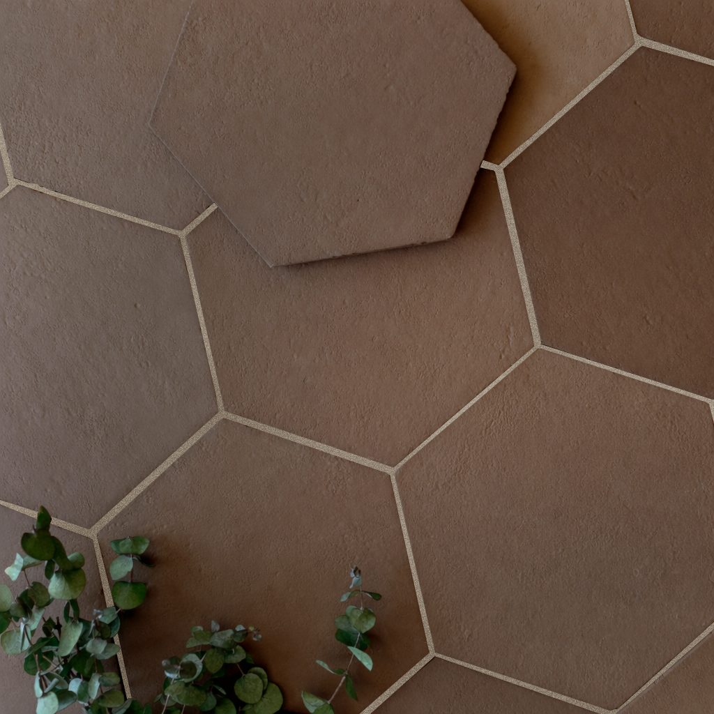 Overhead view of hexagonal terracotta tiles with eucalyptus sprigs adding natural green contrast on floor surface