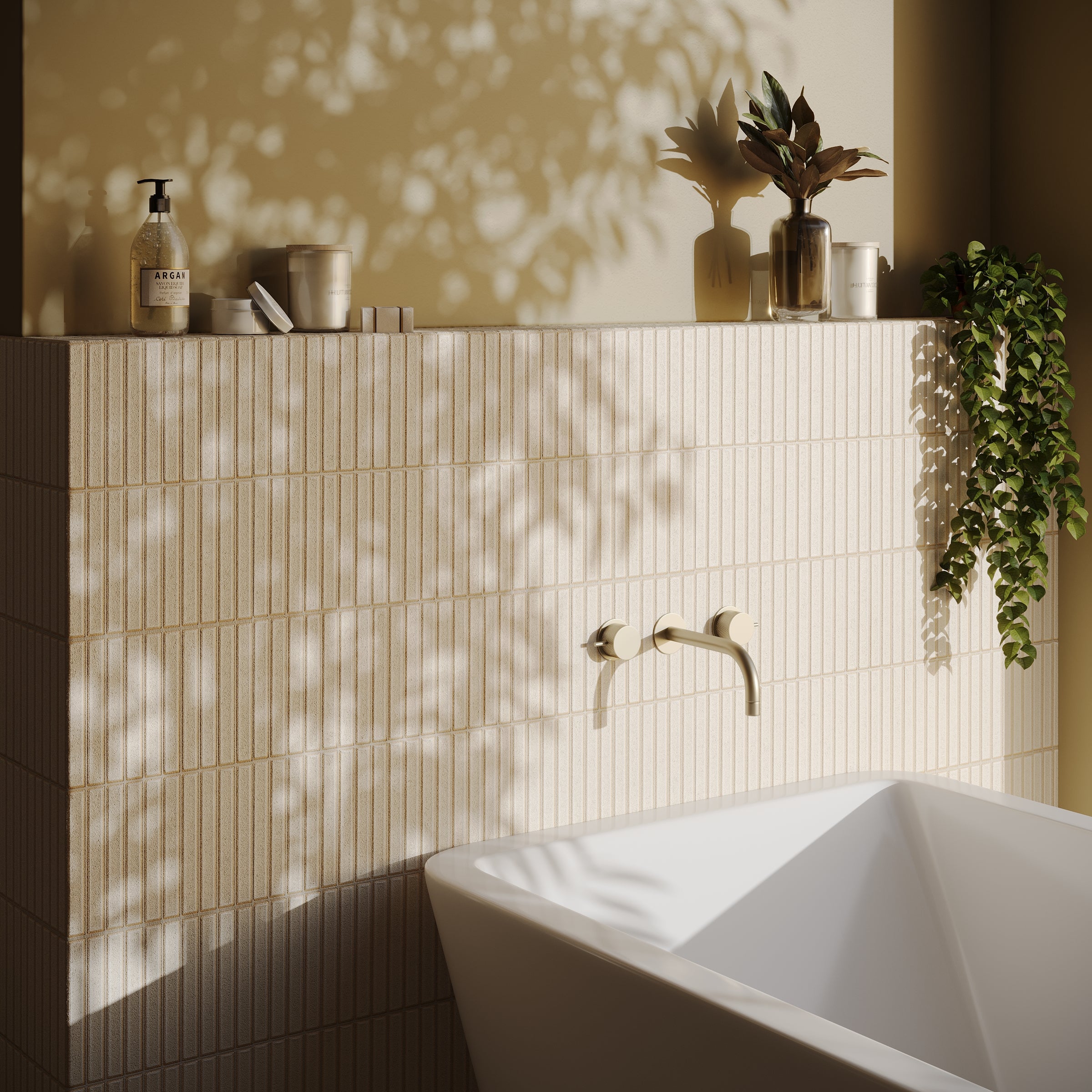 Minimalist bathroom scene with beige ceramic tile wall, white bathtub, plants, and soft natural light shadows.