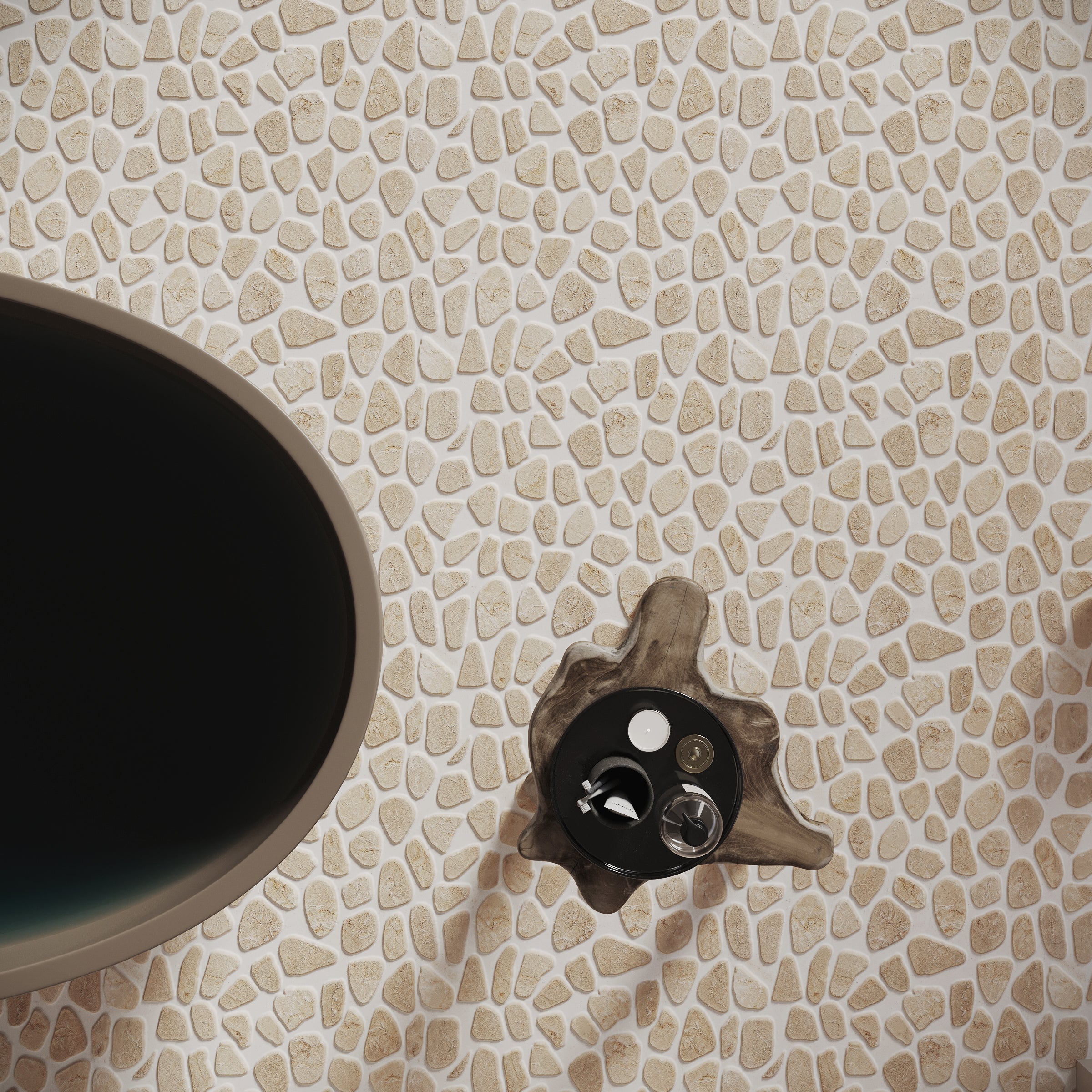 Close-up of cream-colored tumbled pebble mosaic tiles surrounding a dark round basin and modern faucet fixture.