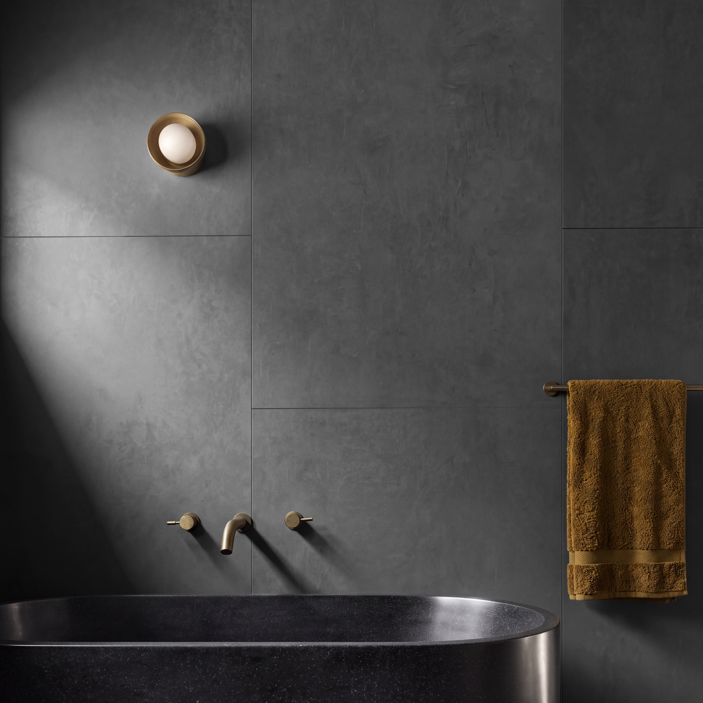 Modern bathroom with dark large format tiles black bathtub brass fixtures and brown towel