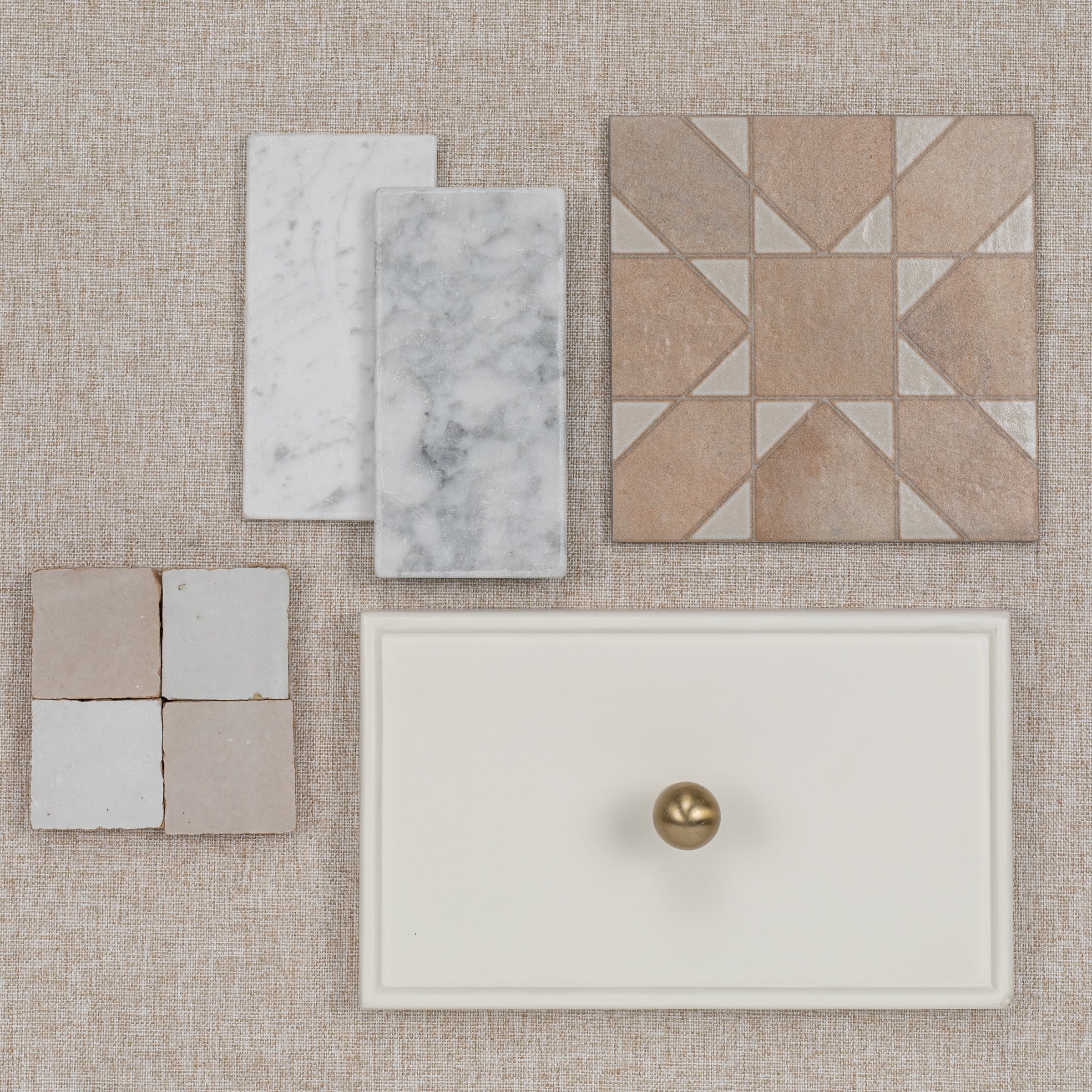 Flat lay of various tile samples including marble, geometric, and plain designs on a textured background