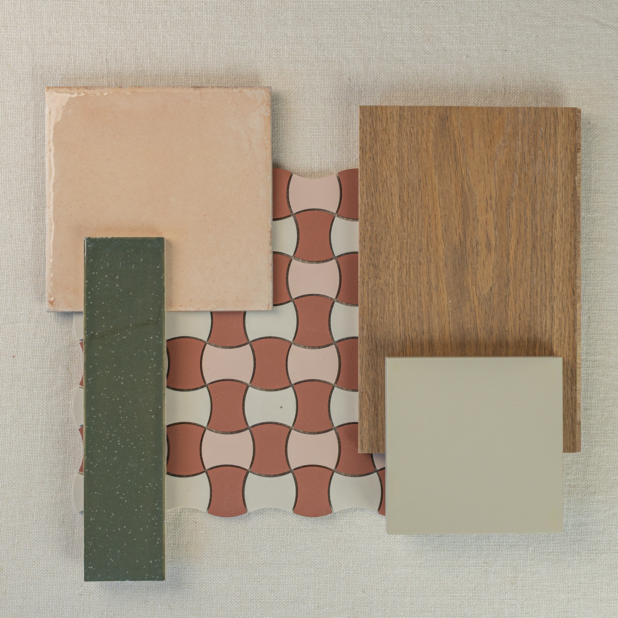 Arrangement of cream ceramic tile, curved terracotta mosaic, green rectangular tile, oak wood veneer, and beige square tile on fabric