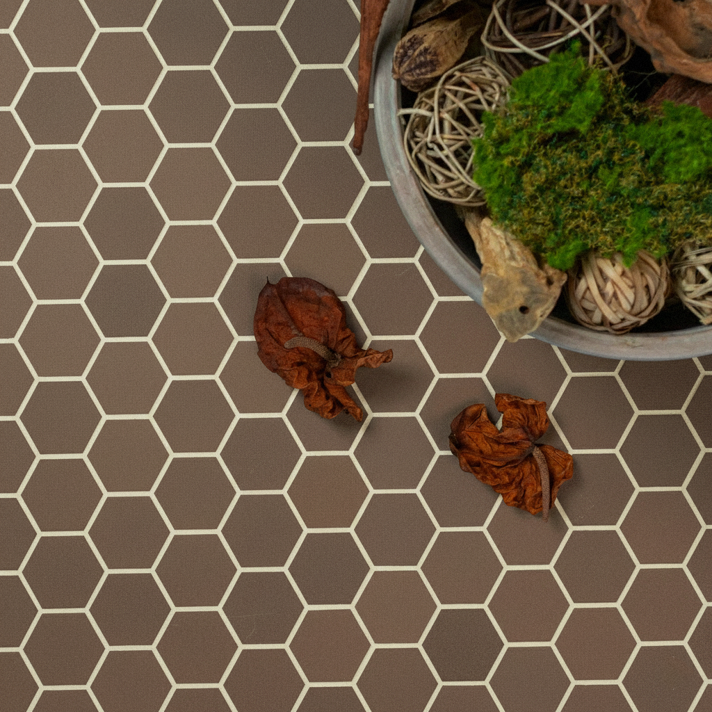 Matte brown hexagonal ceramic tile flooring with natural dried leaves and decorative bowl of moss and wicker balls