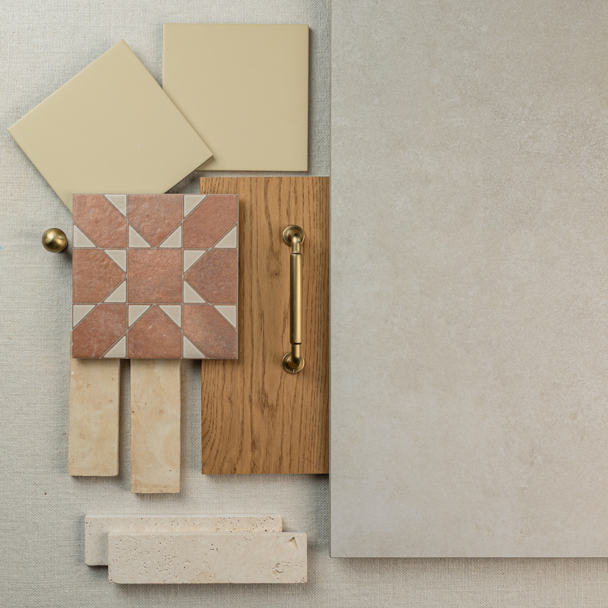 Flat lay featuring large cement-look tile, beige square tiles, terracotta geometric tile, wood sample with brass handle, and stone samples