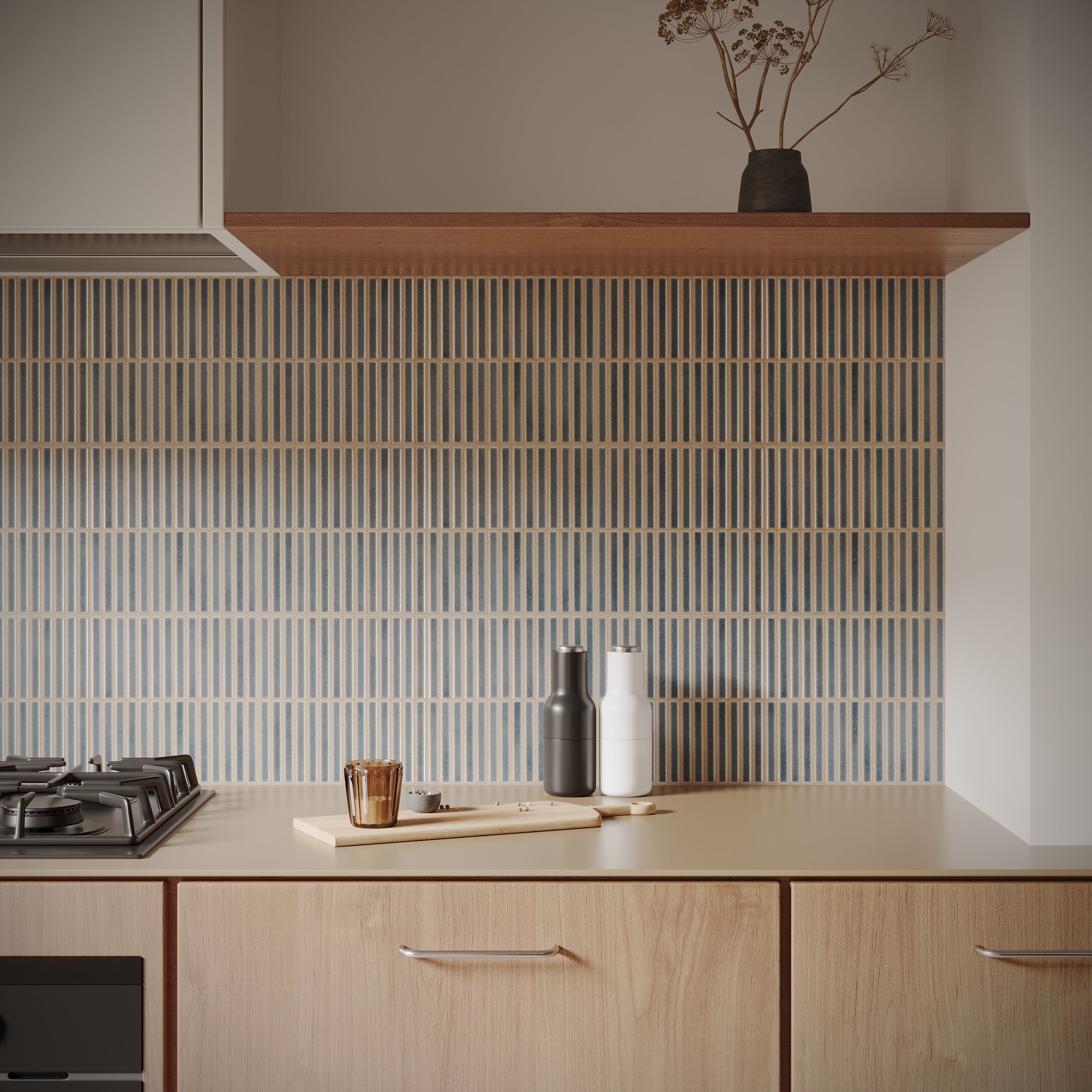 Modern kitchen countertop with light wood cabinets, vertical striped ceramic tile backsplash, and minimal decor.
