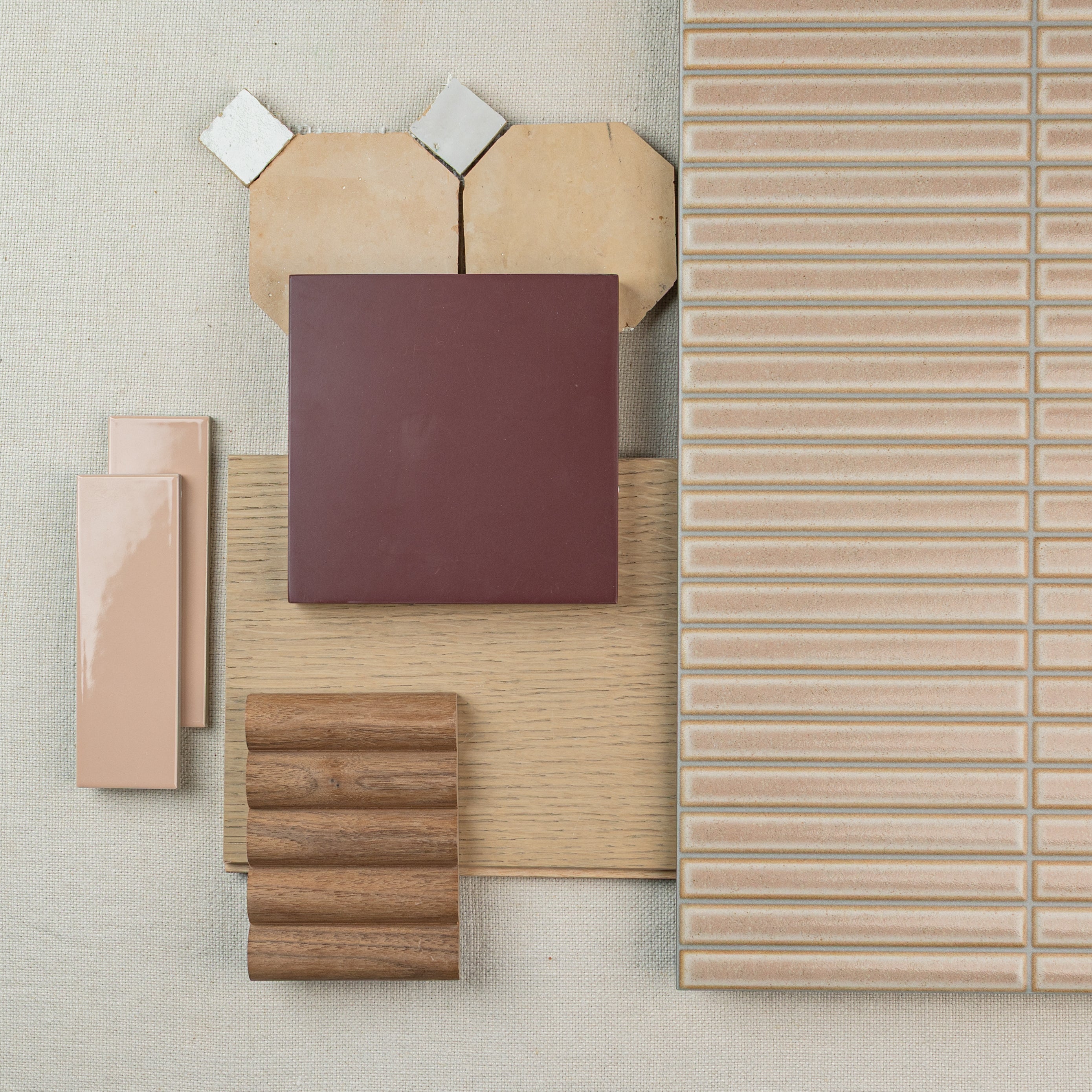 Assortment of nude and beige ceramic and porcelain tiles with wood and textured finishes arranged on neutral fabric background