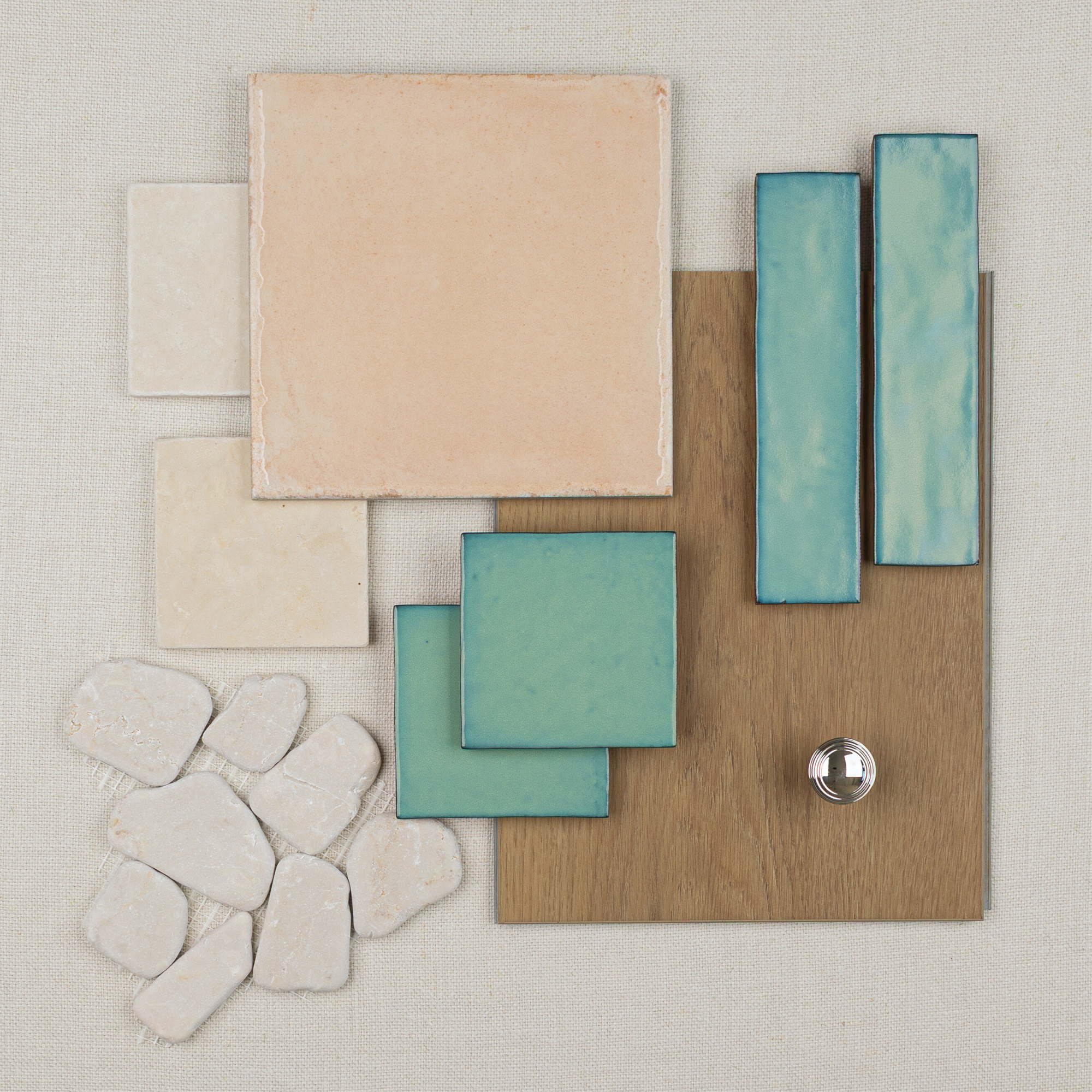 Flat lay of terracotta, cream, and turquoise ceramic tiles with irregular stone pieces, wood sample, and metal knob on fabric