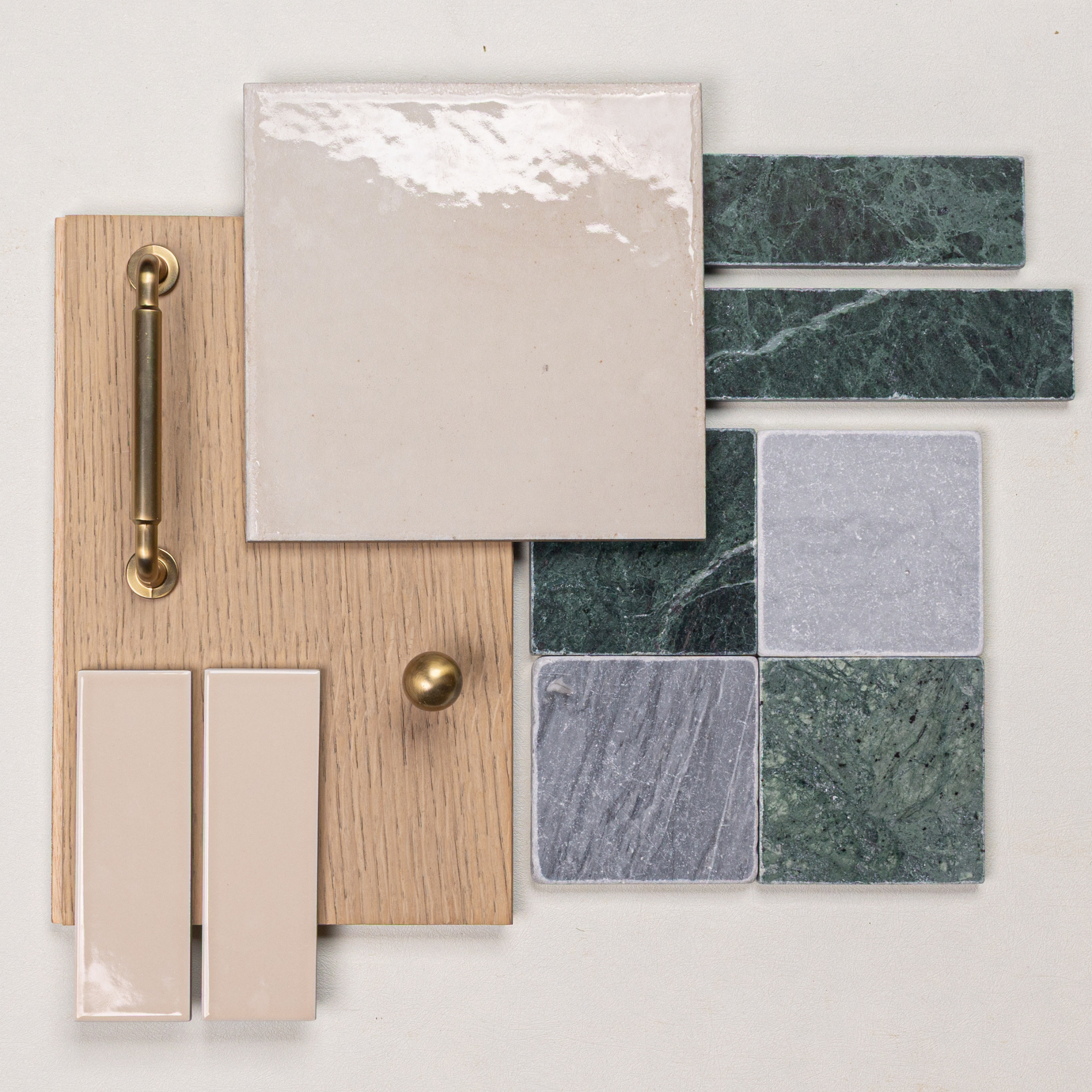 Square glossy ceramic tile, green marble tiles, light oak wood with brass handle and knob on neutral surface