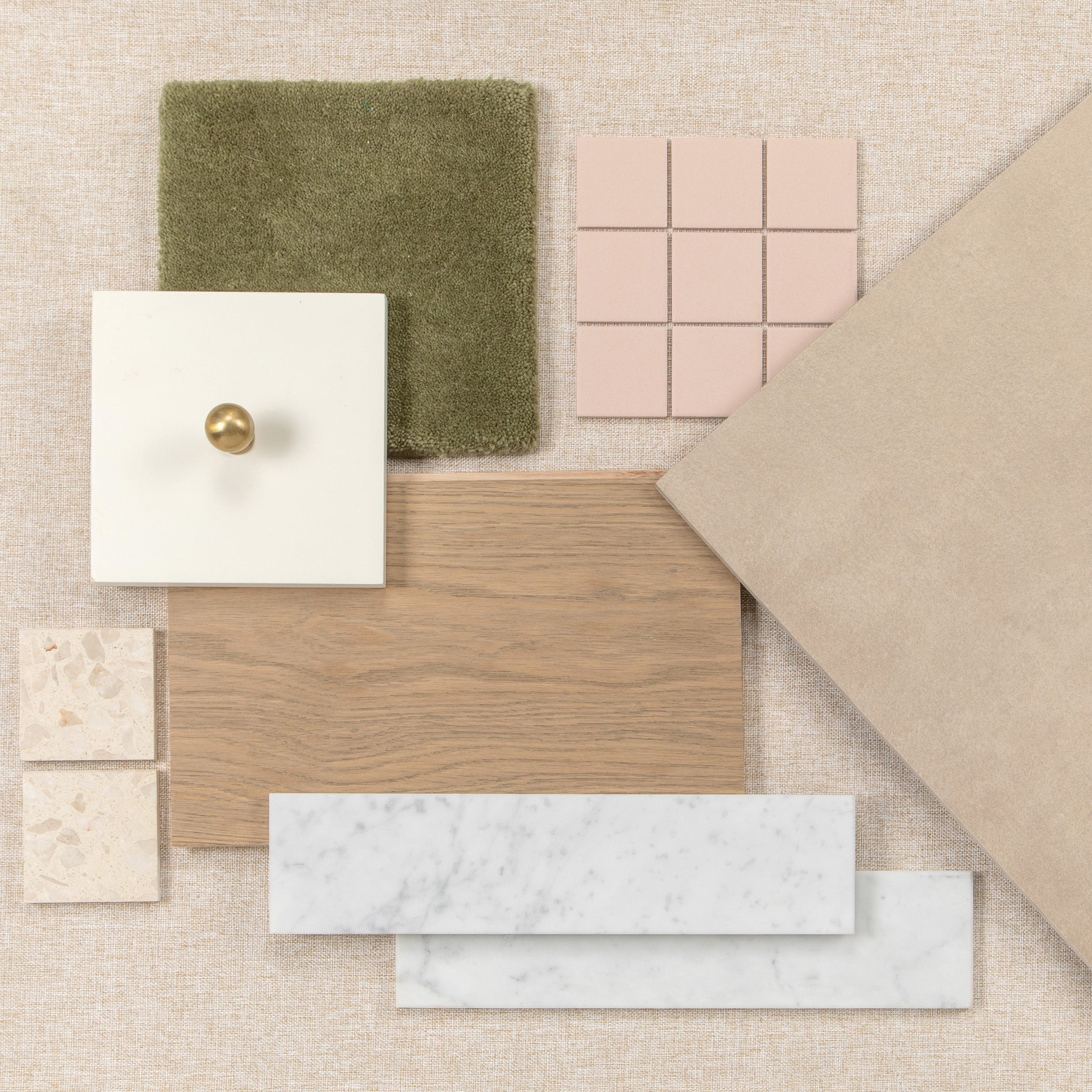 Interior materials mood board with wood flooring, ceramic tiles, stone samples and a brass hardware knob