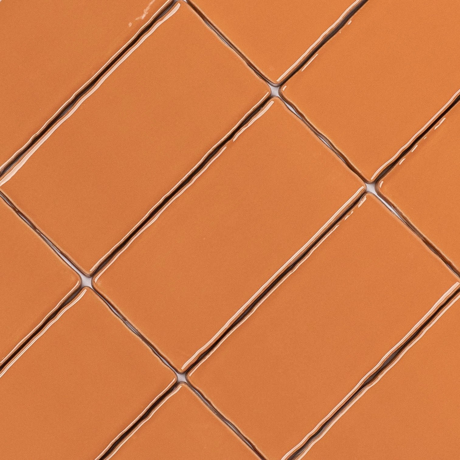 Terracotta 3x6 Glossy Ceramic Tile in warm burnt orange with a glossy finish and slightly irregular edges from Seville collection