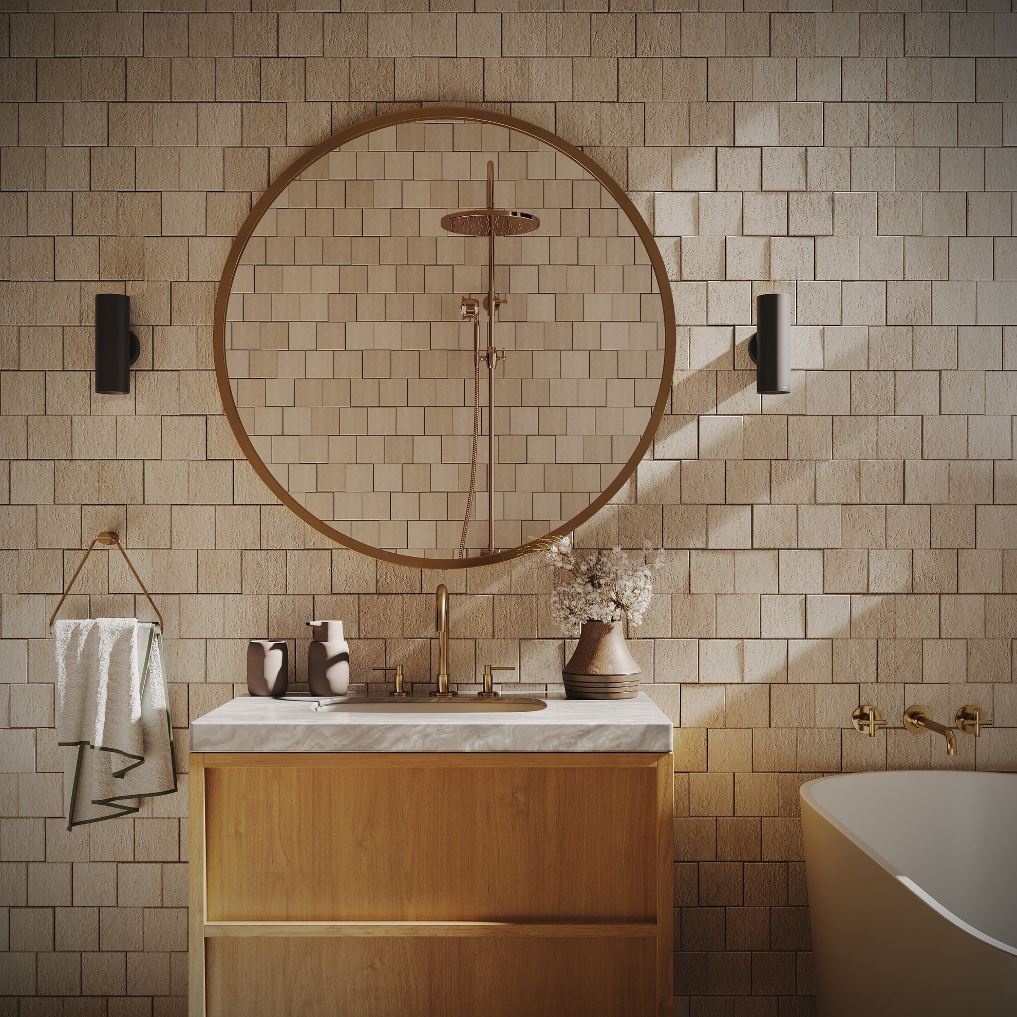 Modern bathroom with wood vanity, round mirror, beige tile wall, brass fixtures, and a white freestanding bathtub.