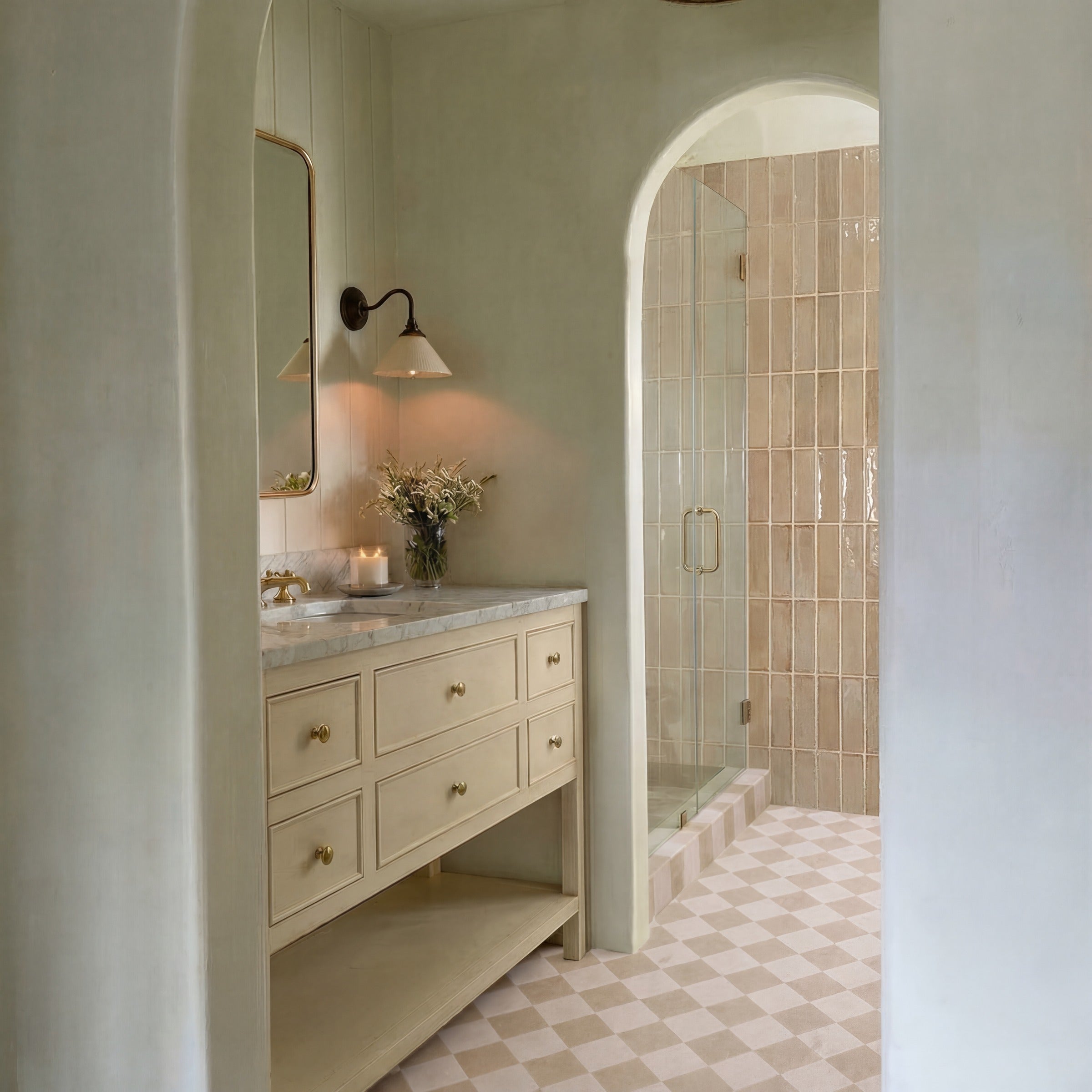 Light neutral plaster bathroom with arched doorway, beige vanity with marble countertop, and glossy rectangular tiles in shower.