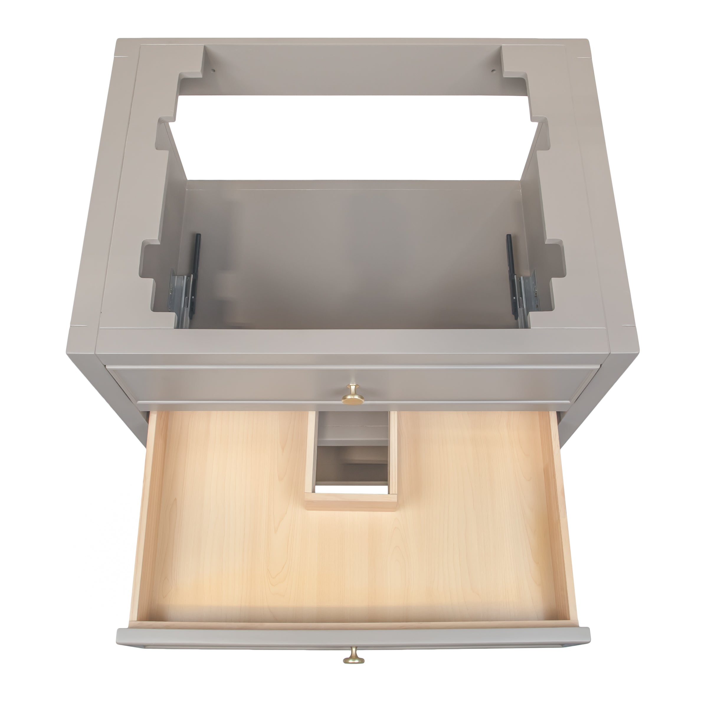 Top view of a taupe wooden vanity frame with dovetail joints and an open drawer revealing a light wood interior and plumbing cutout