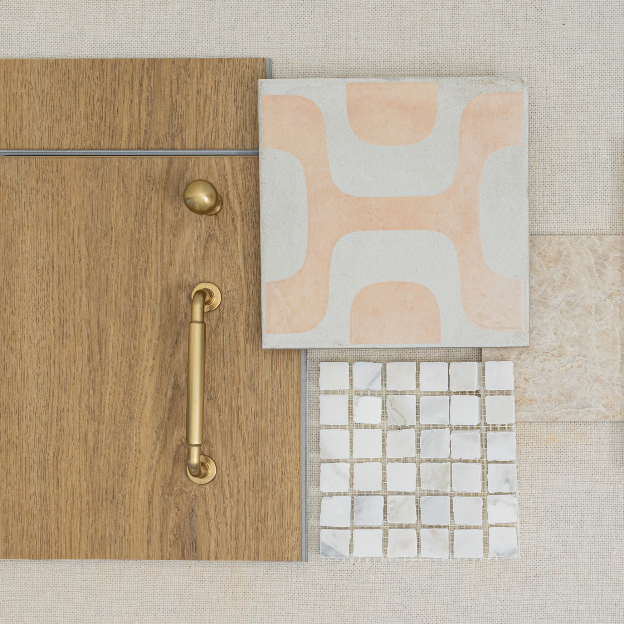 Arrangement of oak wood with brass handle and knob, peach and white abstract tile, small white mosaic tiles, and beige stone tile