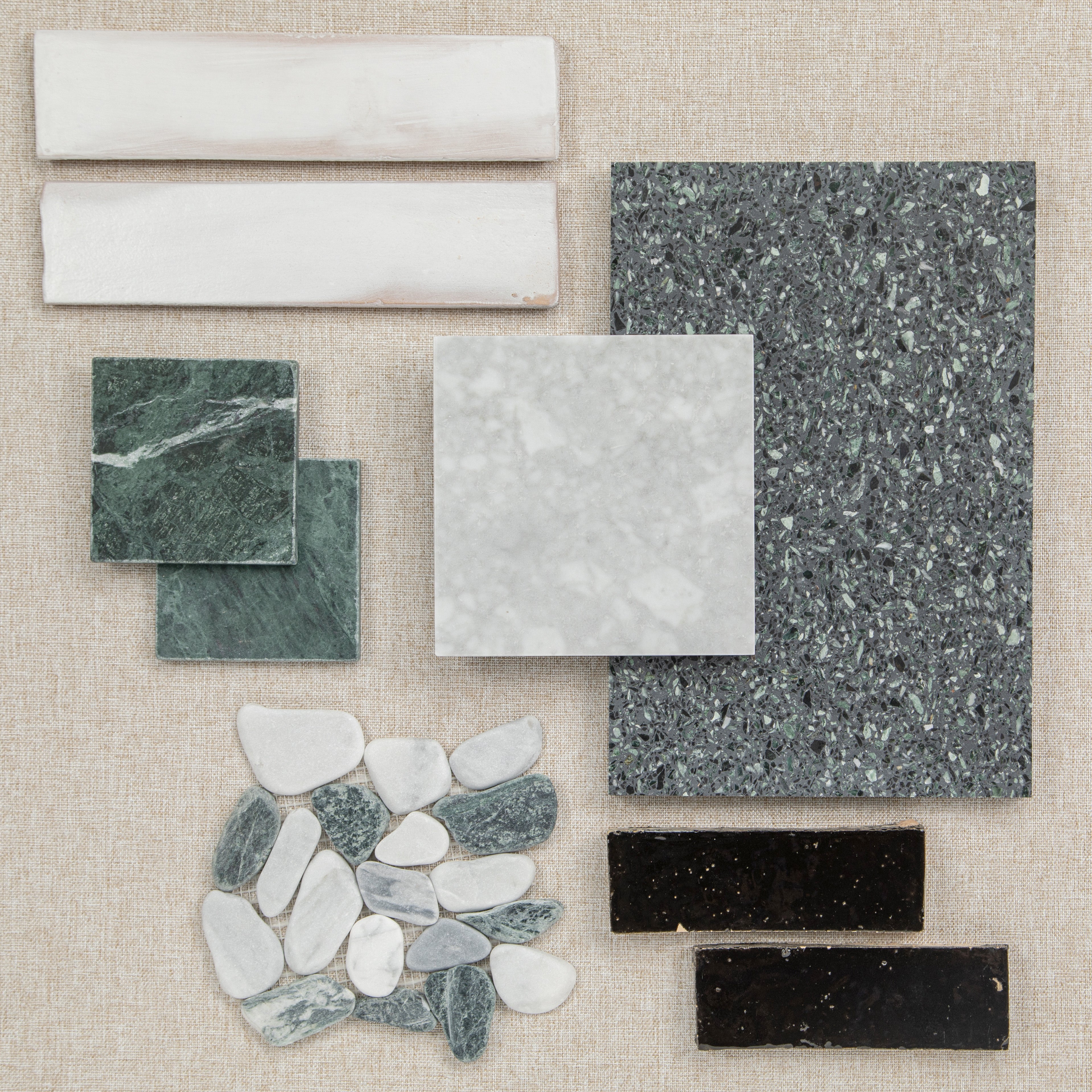Various ceramic and porcelain tile samples in different shapes and colors arranged on a beige background