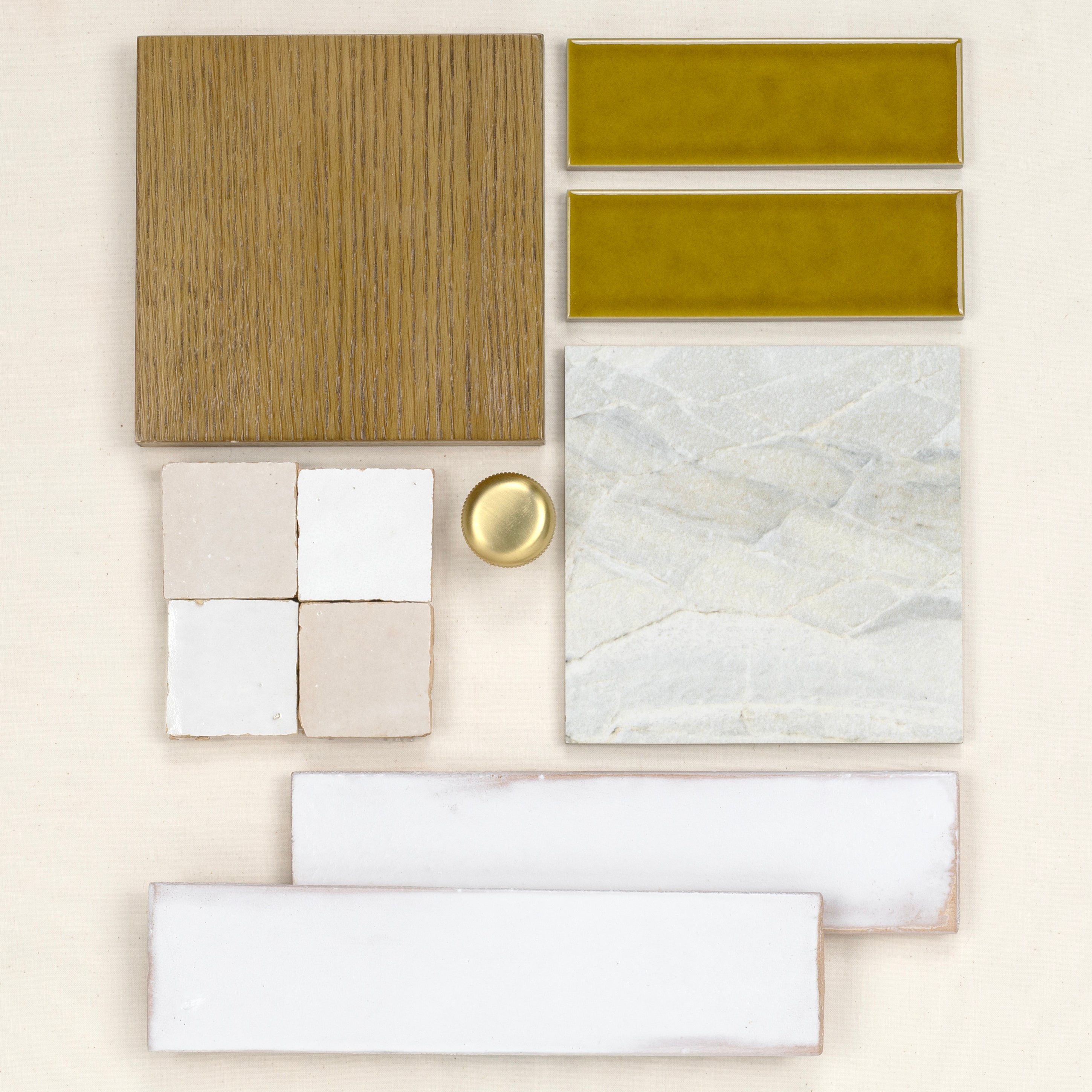 Arrangement of olive green ceramic tiles, natural wood veneer, textured stone tile, beige square tiles, and white elongated porcelain tiles with a brass knob