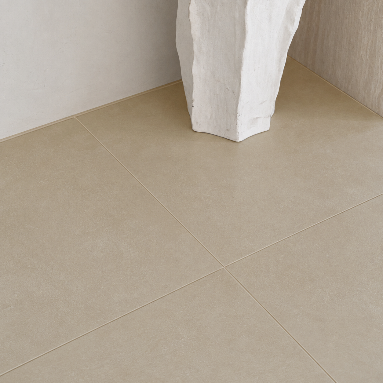 Large beige floor tiles with subtle texture and fine grout lines beside a white sculptural column