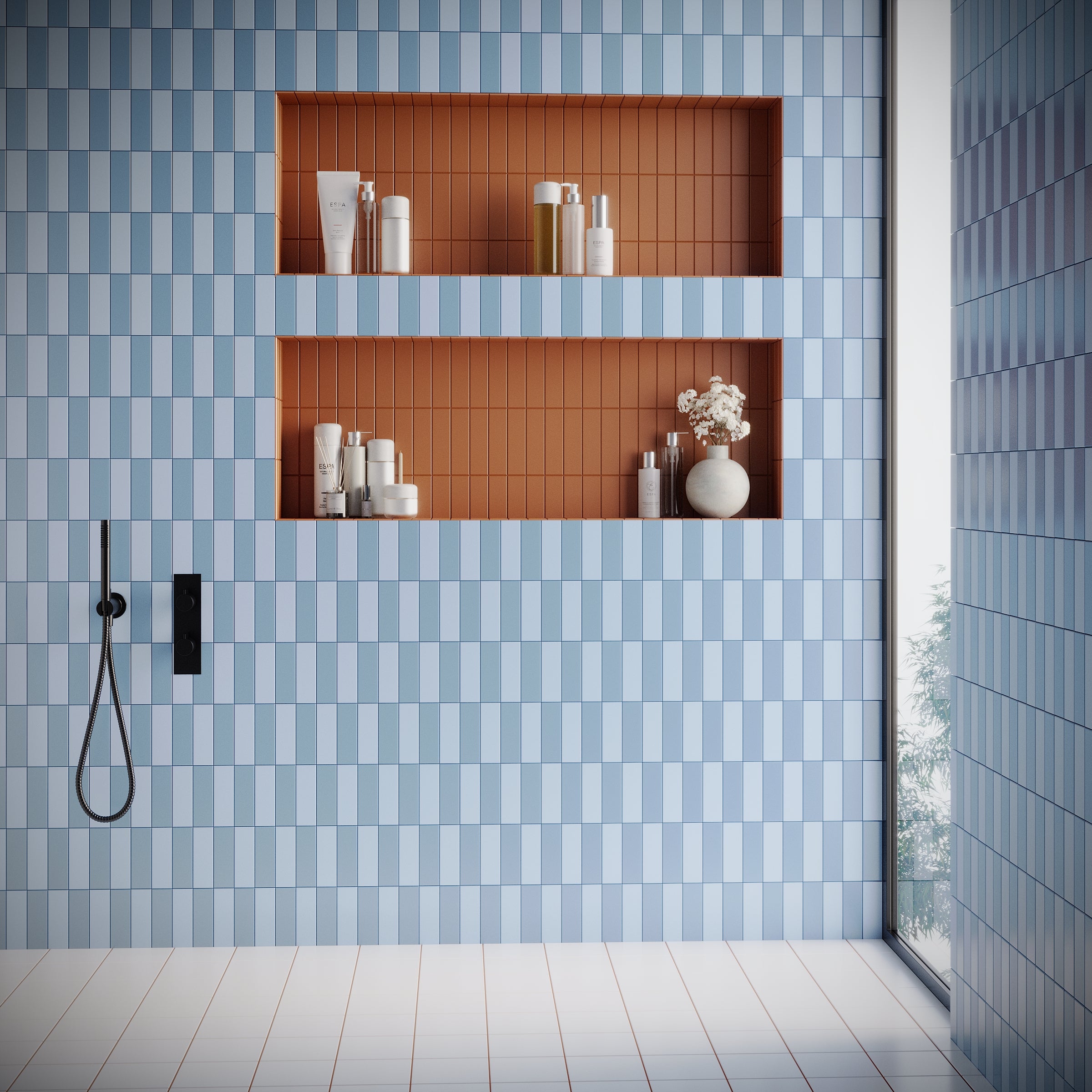 Bathroom wall with vertical rectangular blue tiles and recessed niches lined with small rust-colored tiles holding toiletries