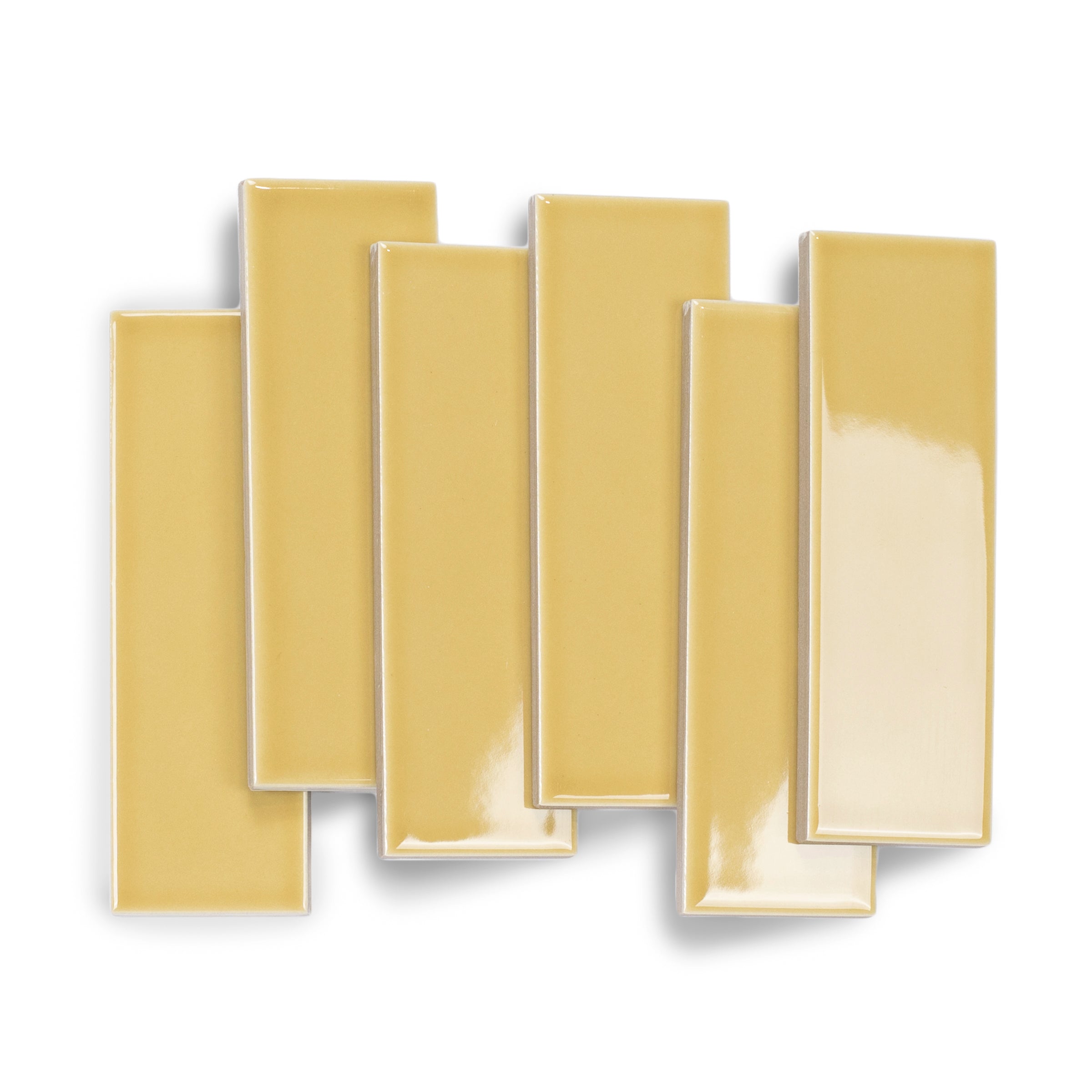 Glossy slim rectangular porcelain tiles in warm golden yellow with smooth surfaces arranged on white background