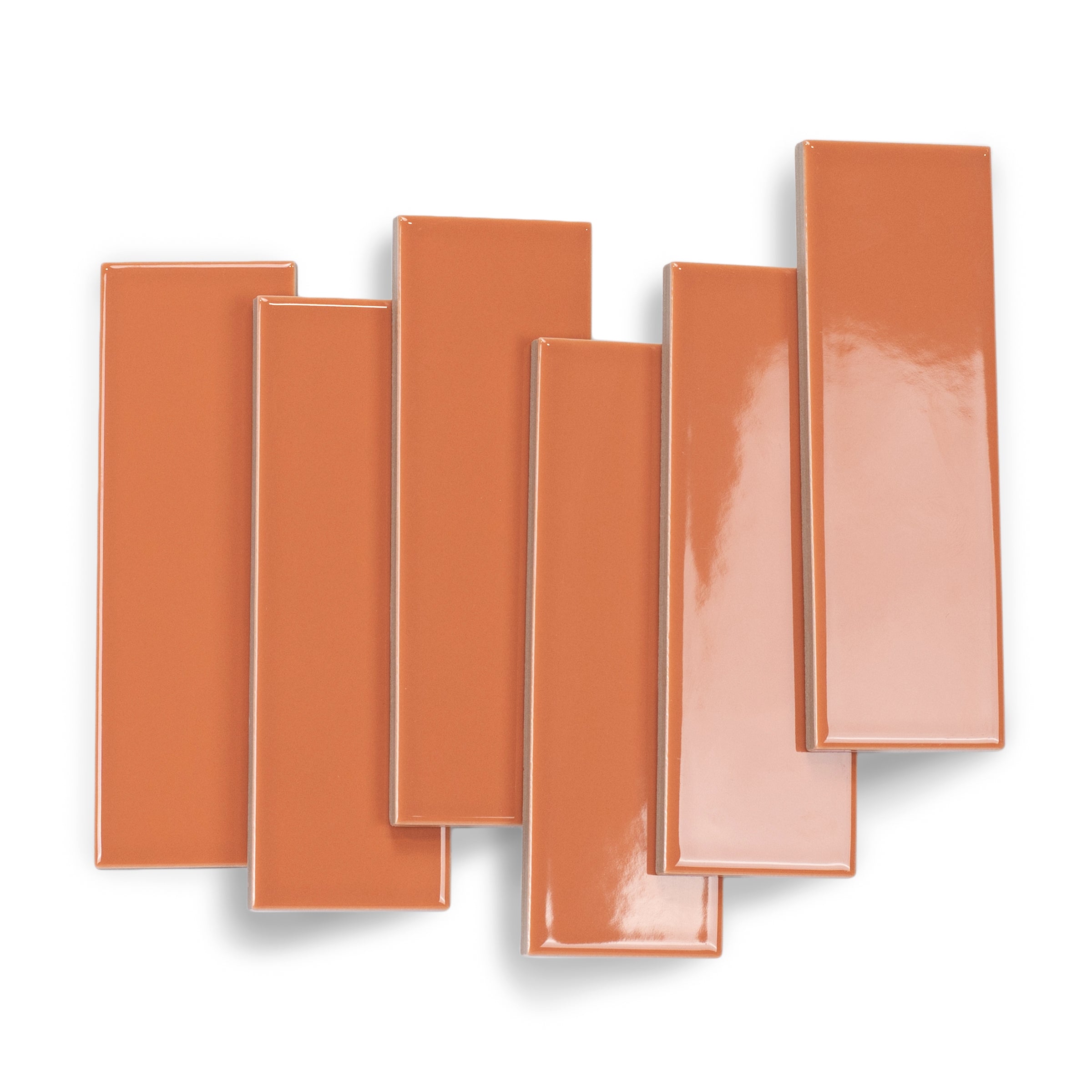 Glossy slim rectangular porcelain tiles in warm terracotta with smooth surfaces arranged on a white background