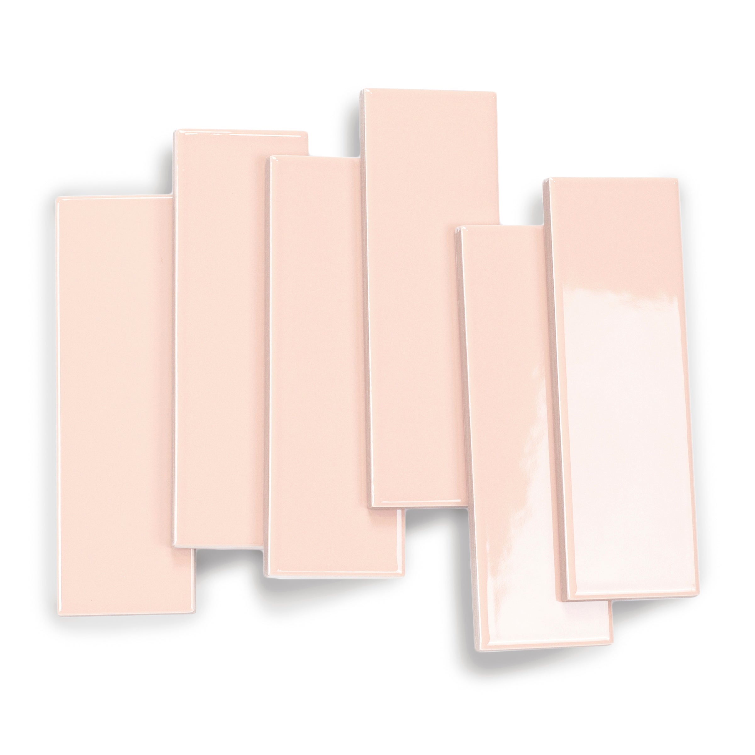 Glossy rectangular porcelain tiles in soft blush pink shade with smooth surfaces arranged overlapping on white background