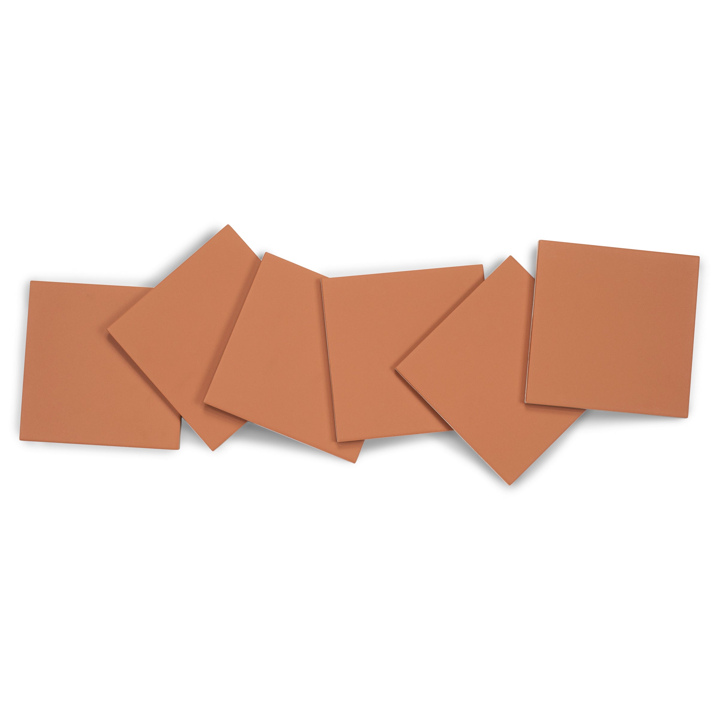 Matte terracotta porcelain tiles with smooth surfaces and clean edges arranged in a casual overlapping pattern