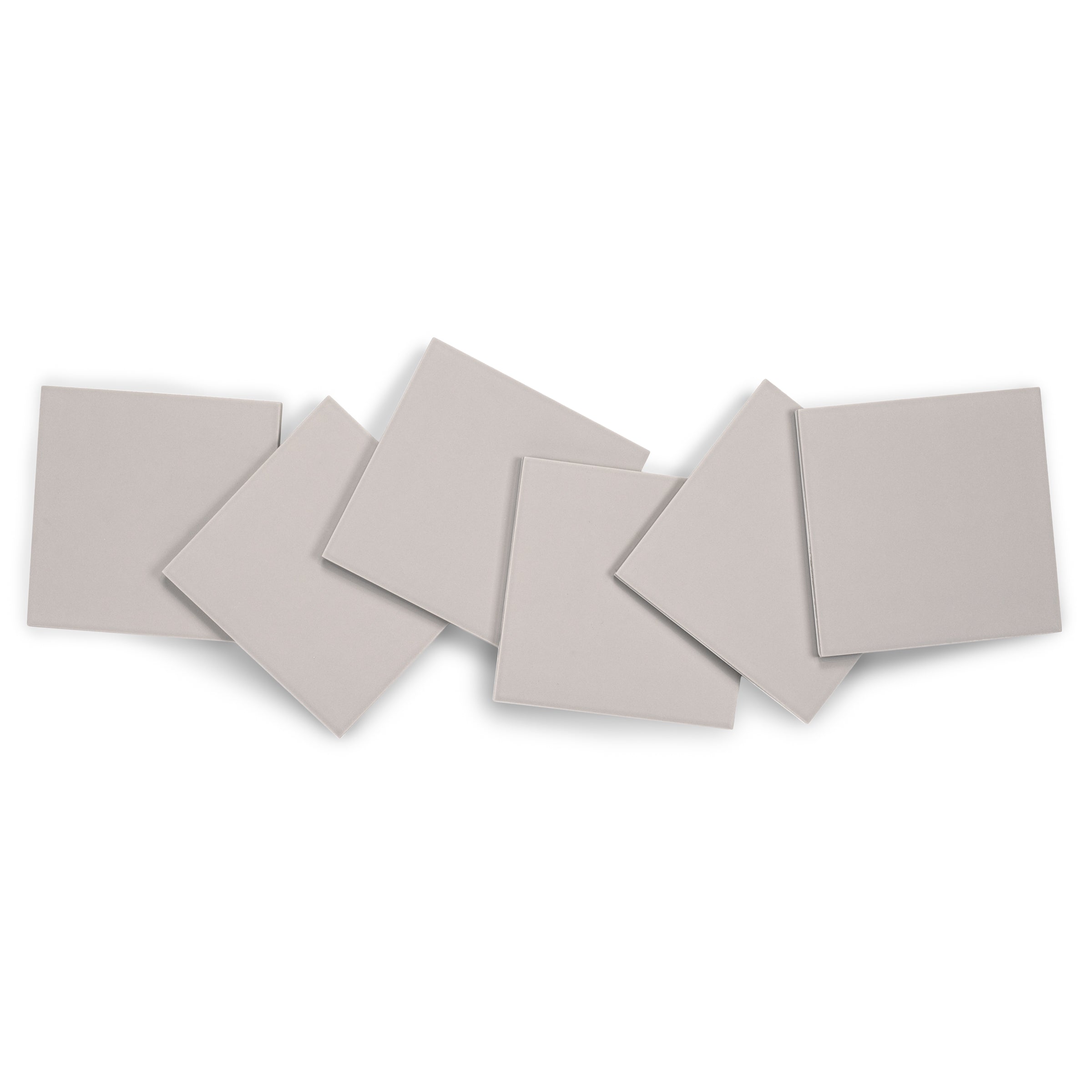 Six light gray matte porcelain tiles arranged in a scattered overlapping pattern on white background