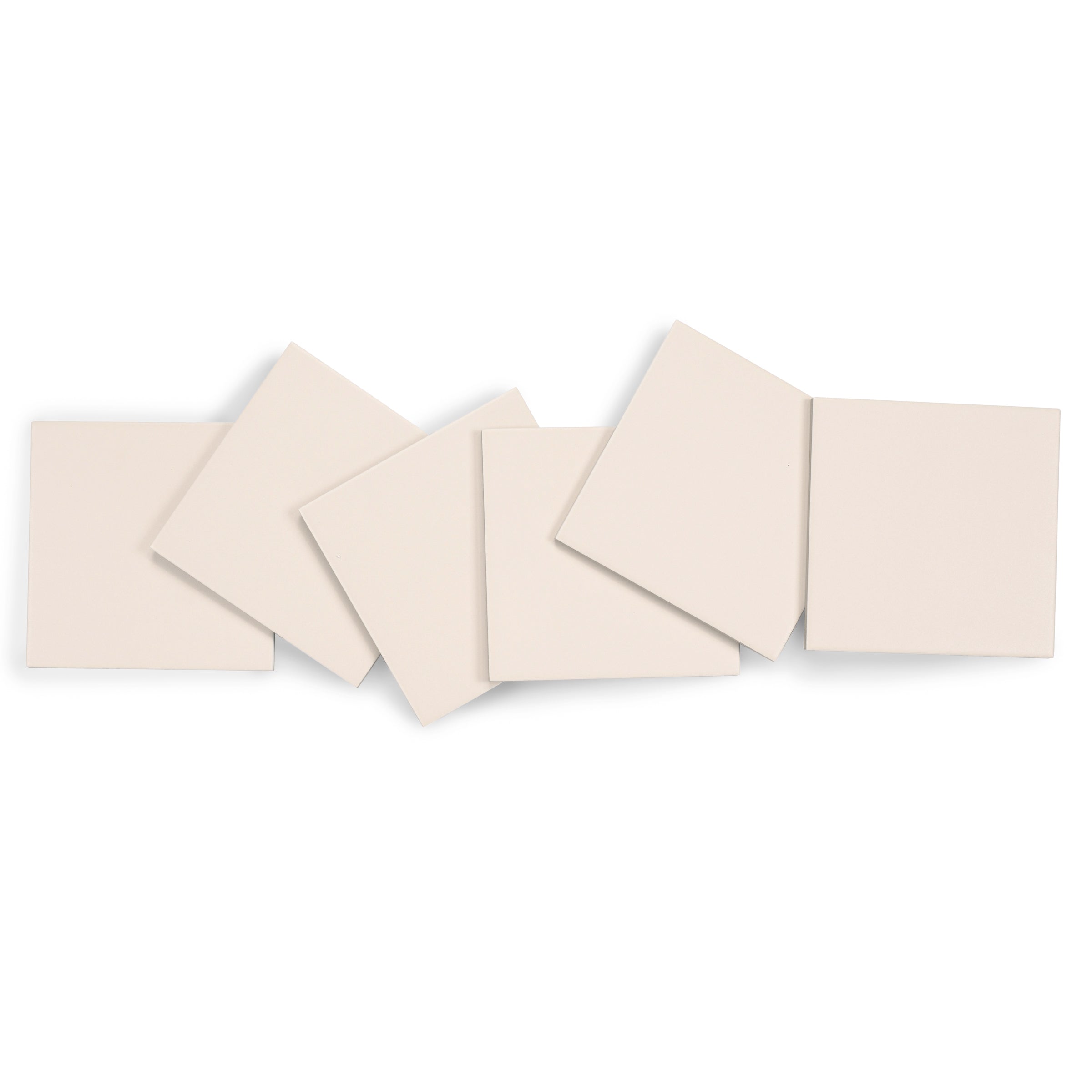Matte porcelain tiles in a soft cream tone, square shape, arranged overlapping on a white background
