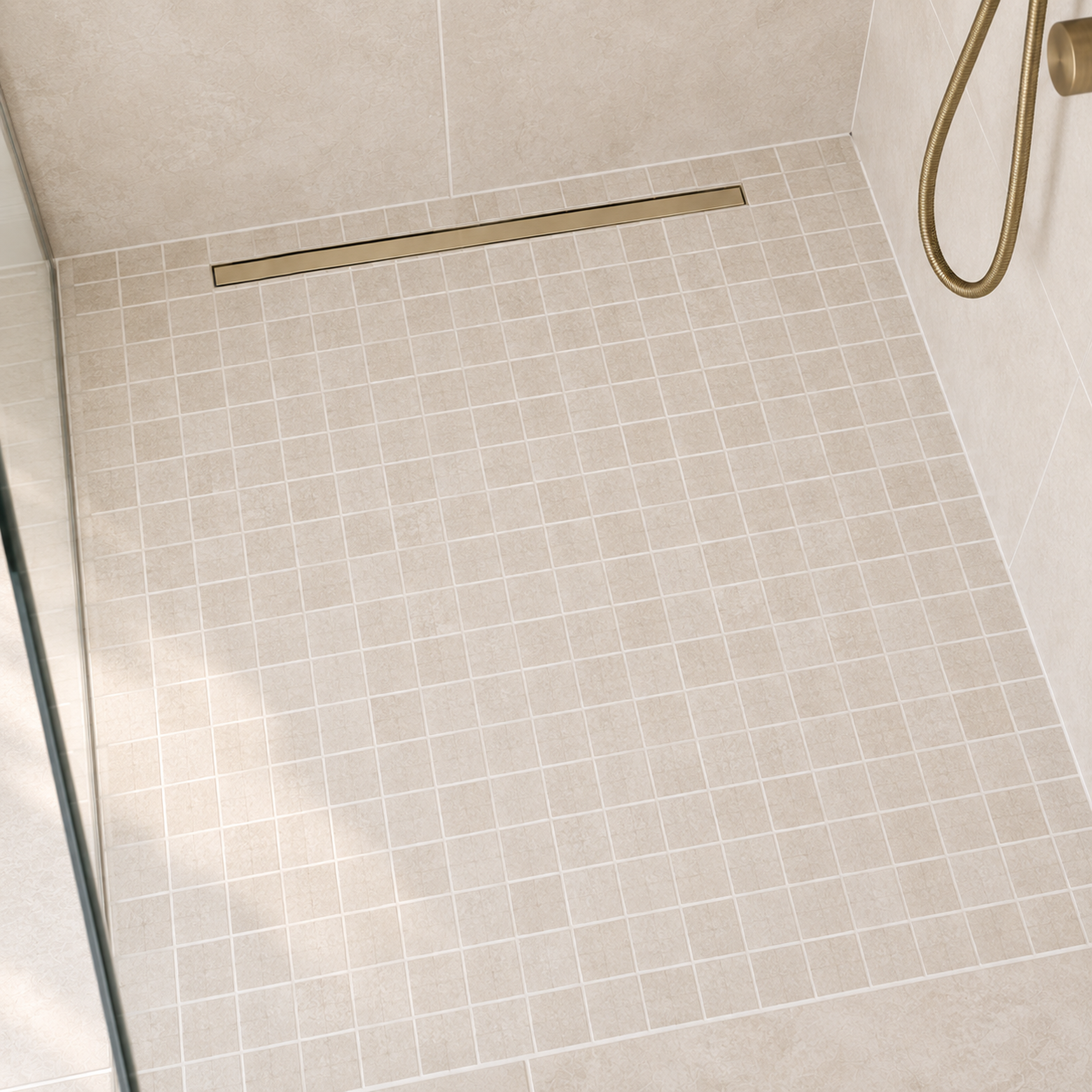 Beige small format tile shower floor with a brass linear drain