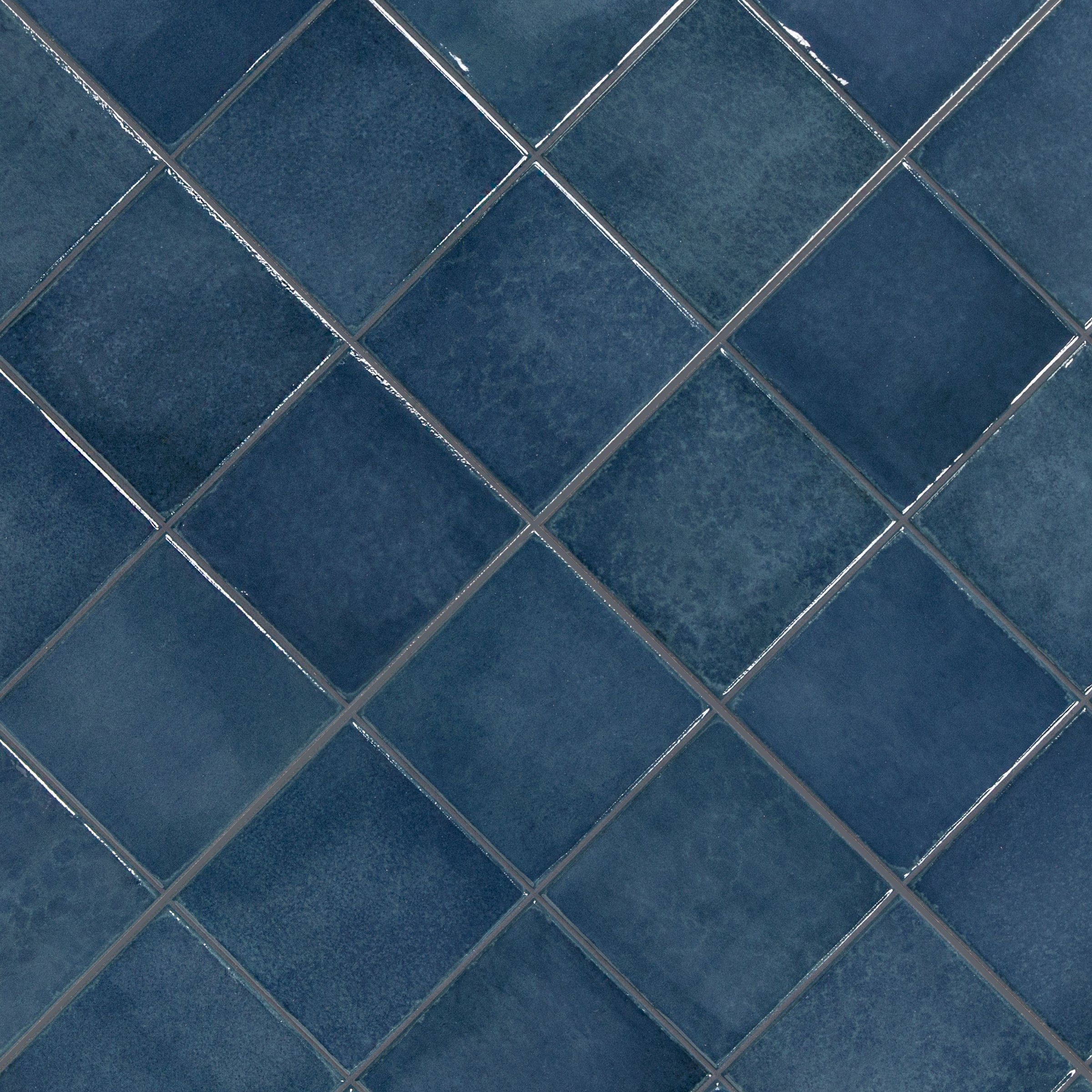Close-up of blue ceramic tiles arranged in a diamond pattern with visible grout lines and subtle texture variations.