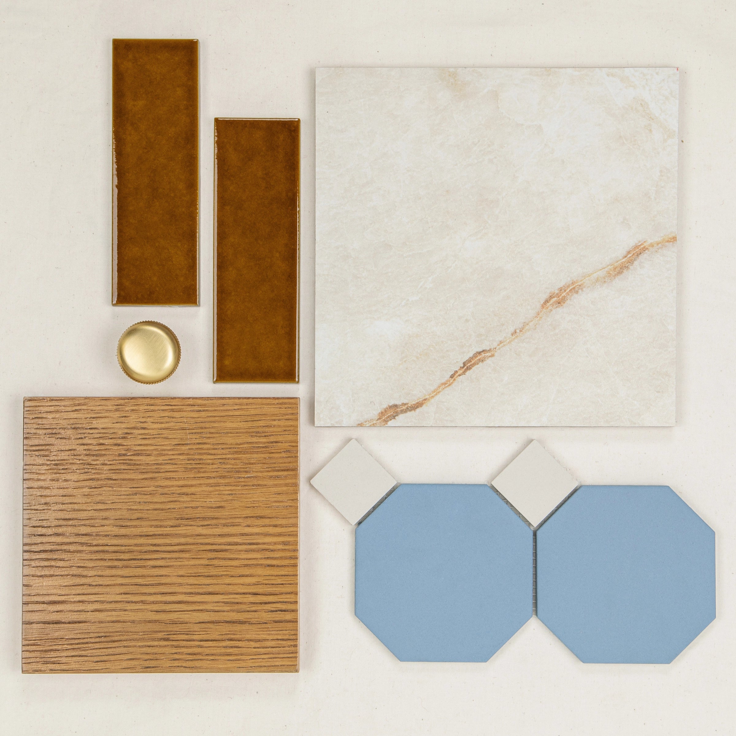 Glossy amber rectangular porcelain tiles, weathered oak wood square, beige marble tile, and muted blue octagonal tiles with brass knob