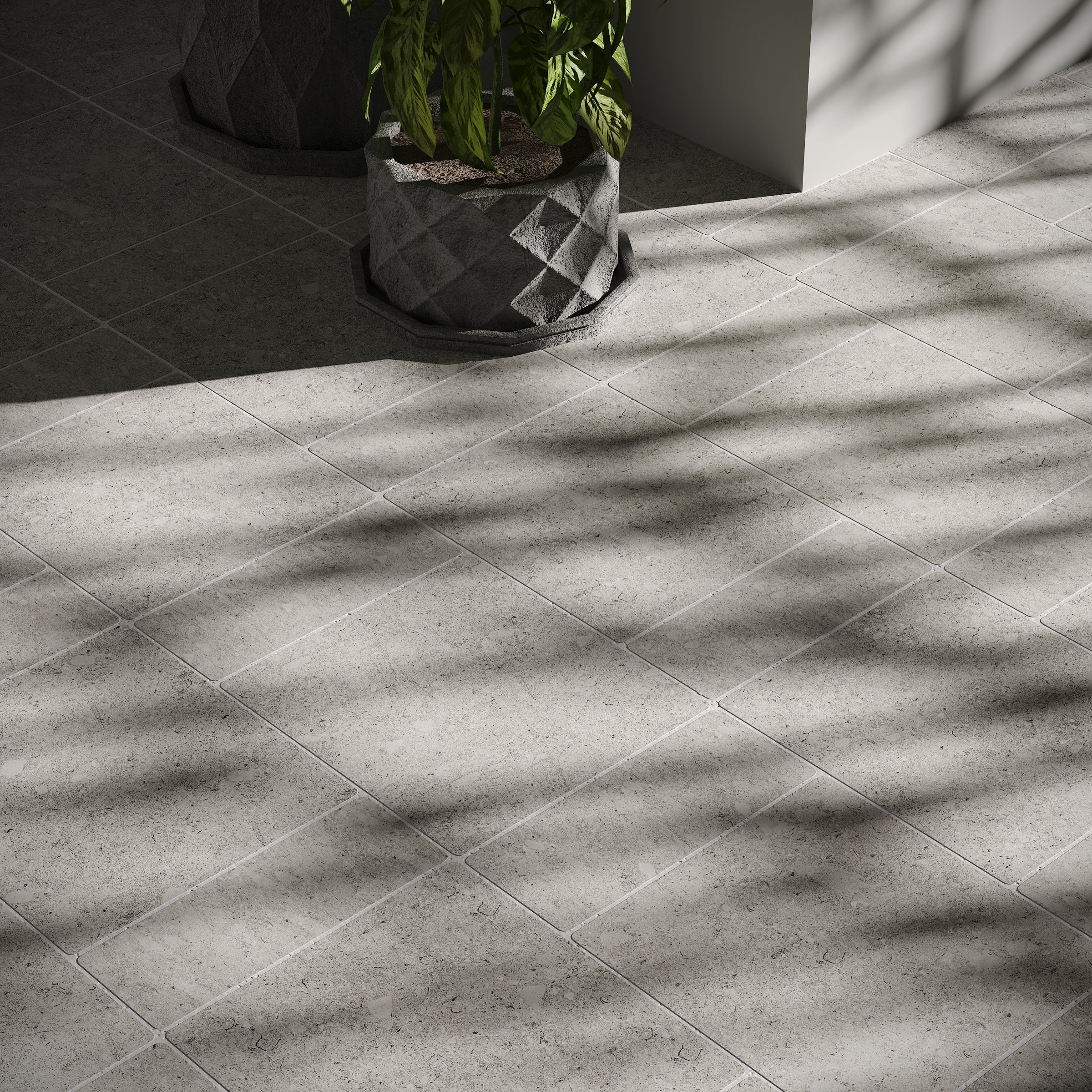 Soft matte ash-colored porcelain tile flooring with natural stone texture and cast shadows from nearby plants.