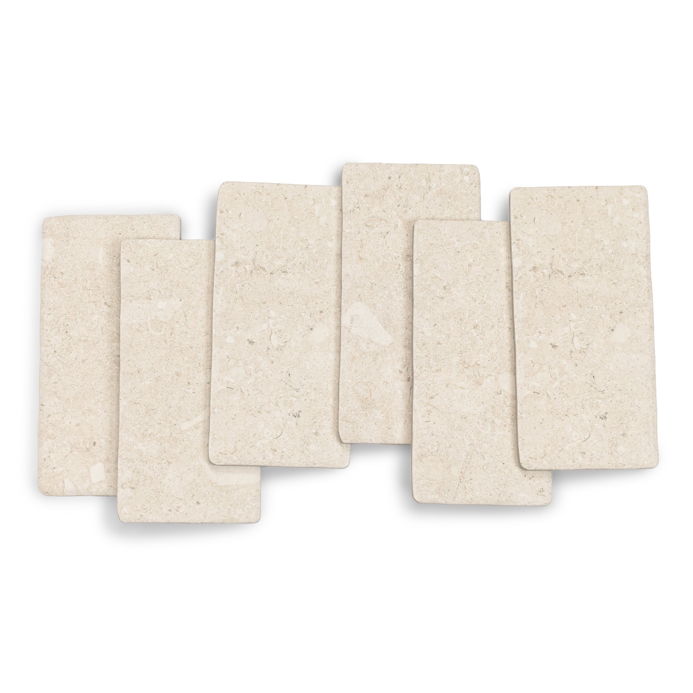 Cream-colored porcelain tiles with subtle natural stone texture arranged in a staggered layout on a white background