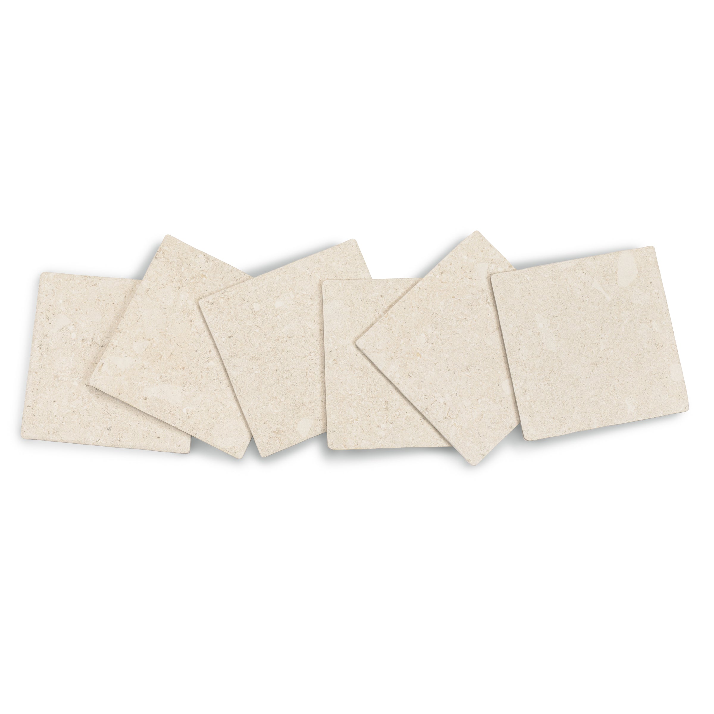 Five small cream-colored tiles with soft stone texture arranged in a casual overlapping pattern on a white surface