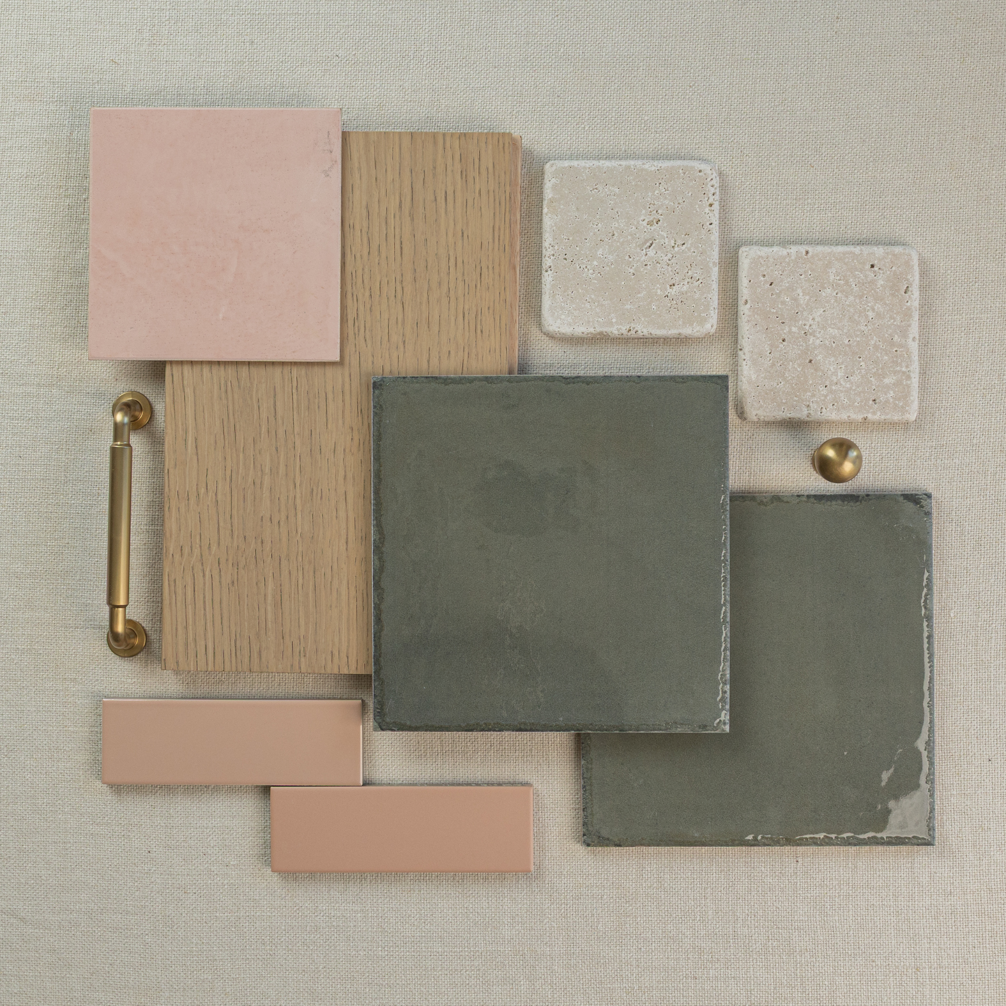 Flat lay of pink ceramic tiles, oak wood samples, textured stone tiles, green matte ceramic tiles, and brass hardware on linen background