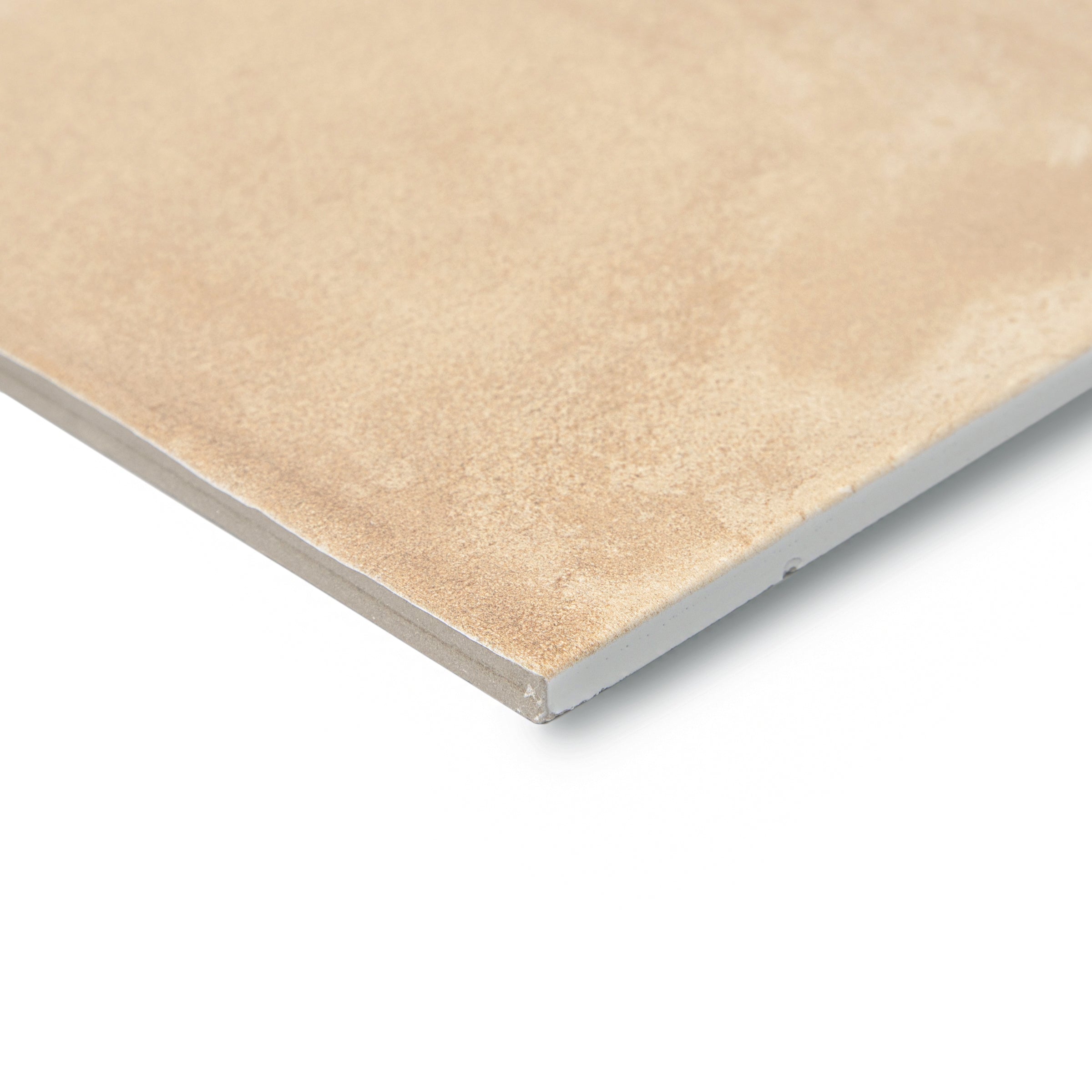Close-up of a beige ceramic tile corner showing texture and smooth edges against a white background
