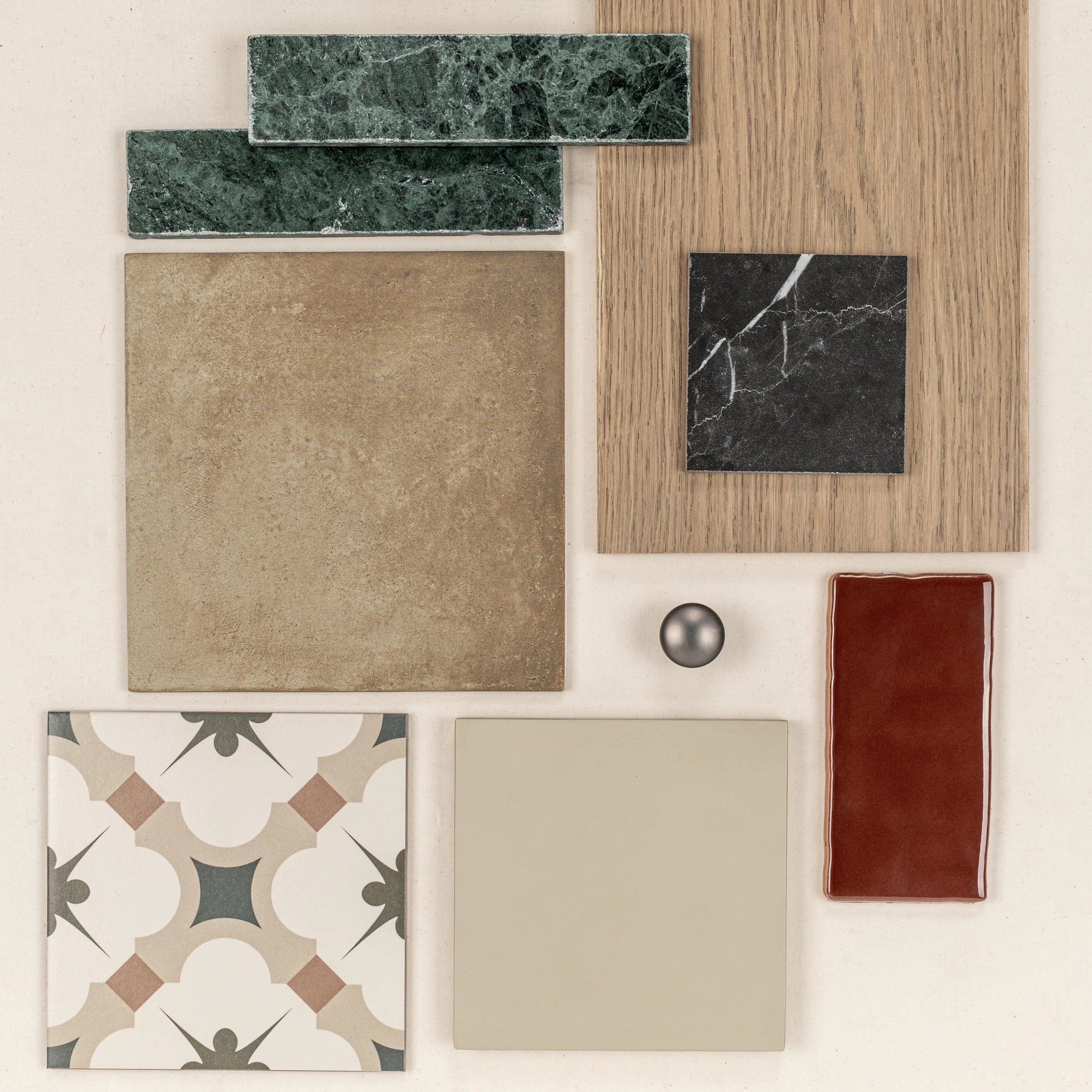 Assortment of ceramic tiles, wood sample, and a small metallic sphere arranged for creative flooring ideas