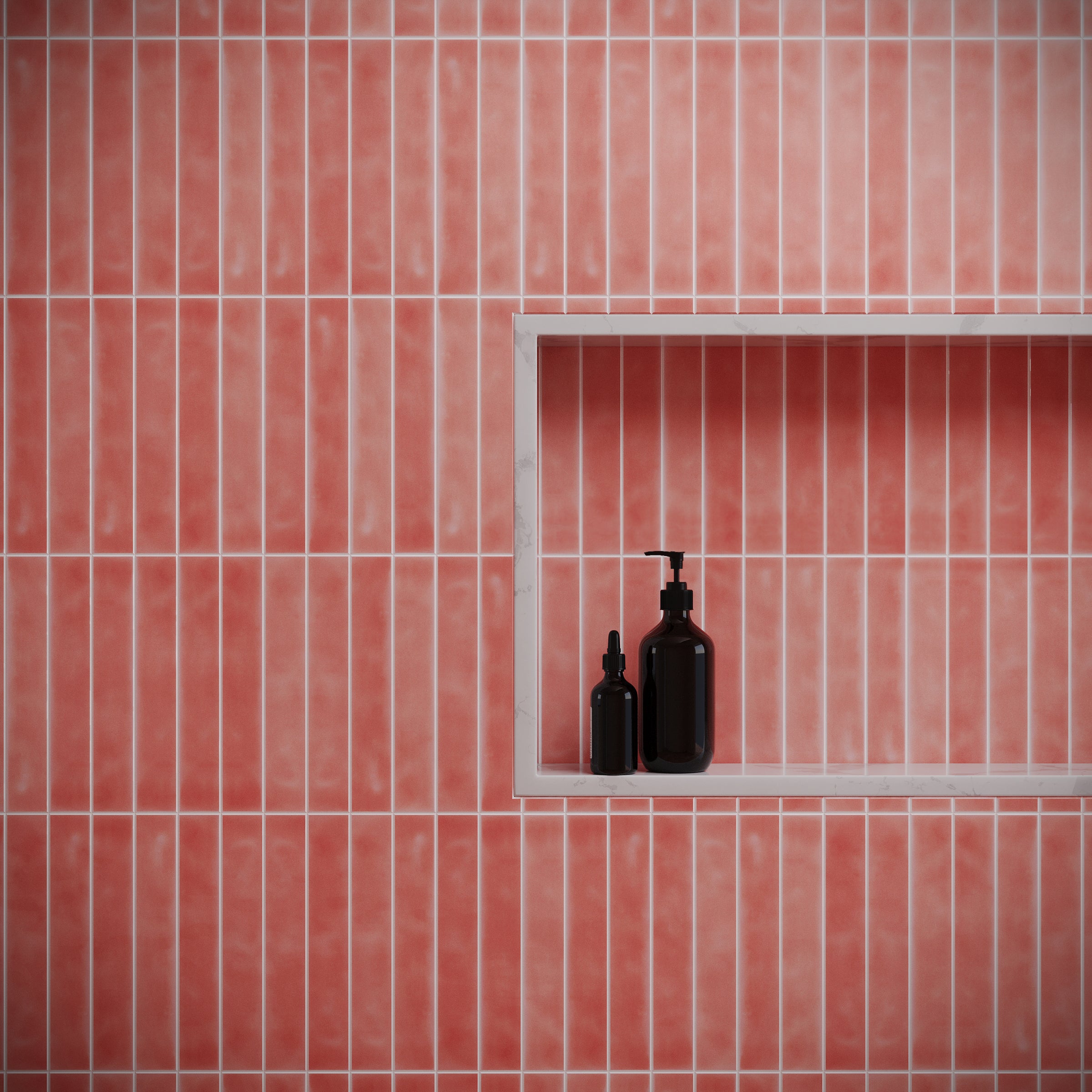 Soft matte coral ceramic tiles in narrow vertical rectangles with white grout and a recessed shelf holding dark bottles