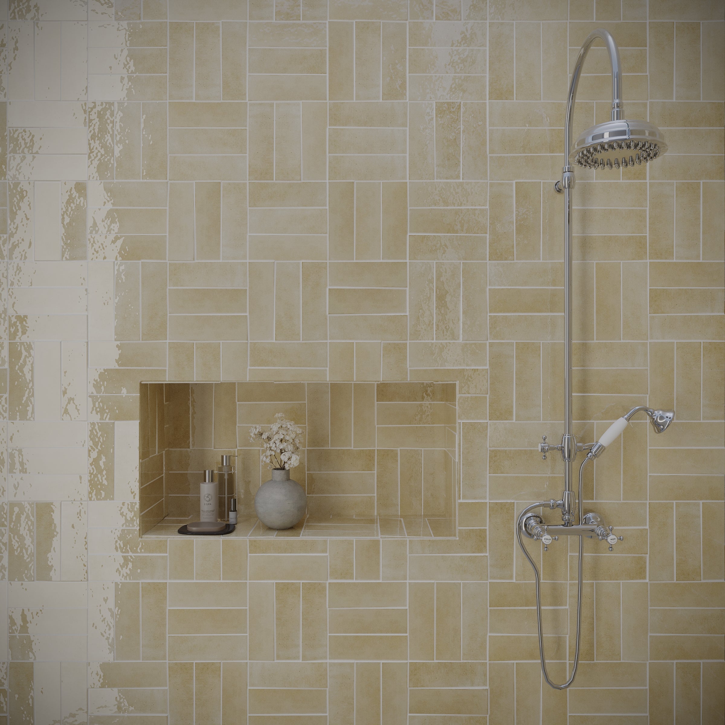 Beige glossy ceramic tiles arranged in a parquet pattern with a built-in shelf and modern showerhead fixture