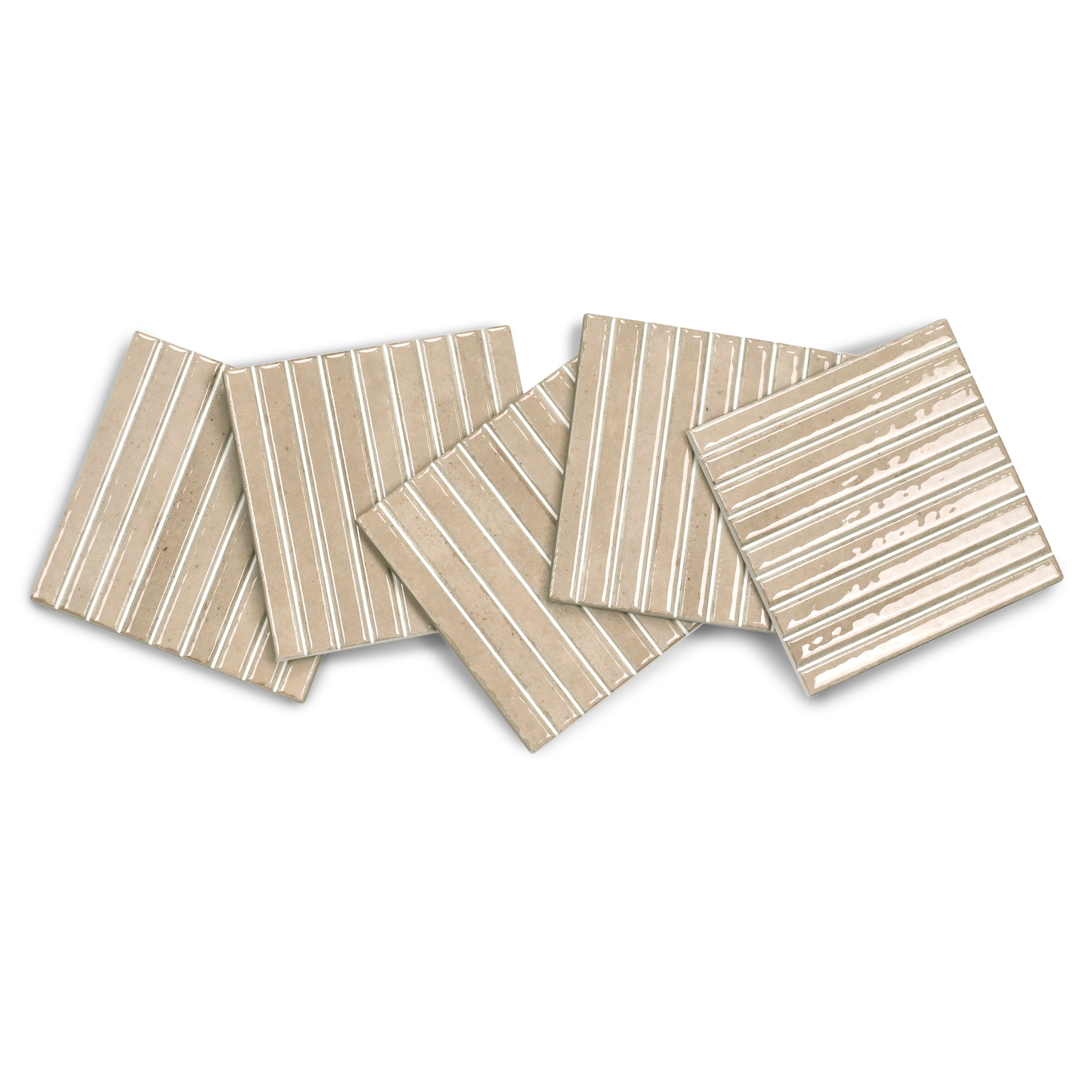 Collection of beige ceramic tiles with white linear patterns arranged on white background