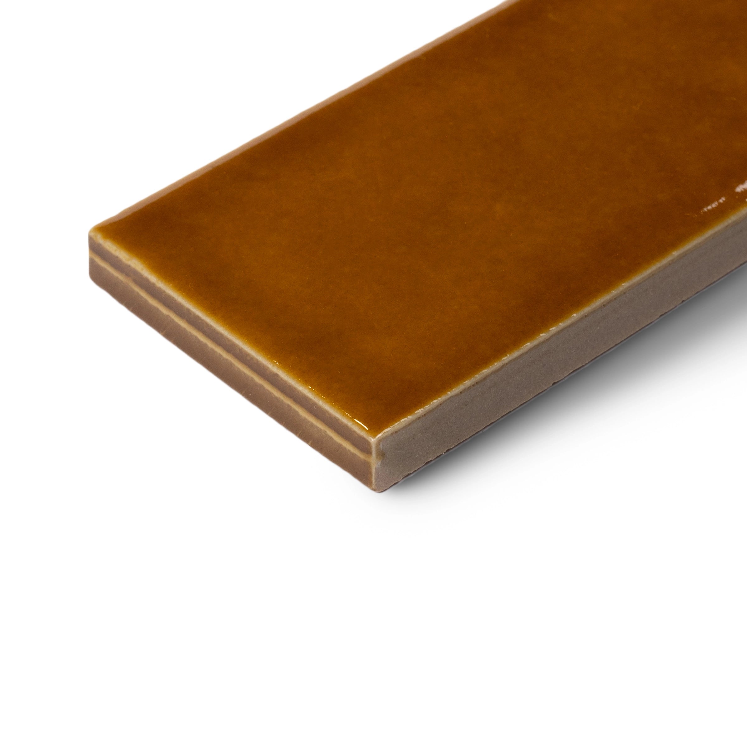 Glossy rectangular ceramic tile in warm amber tone with smooth edges and a subtle depth on white background
