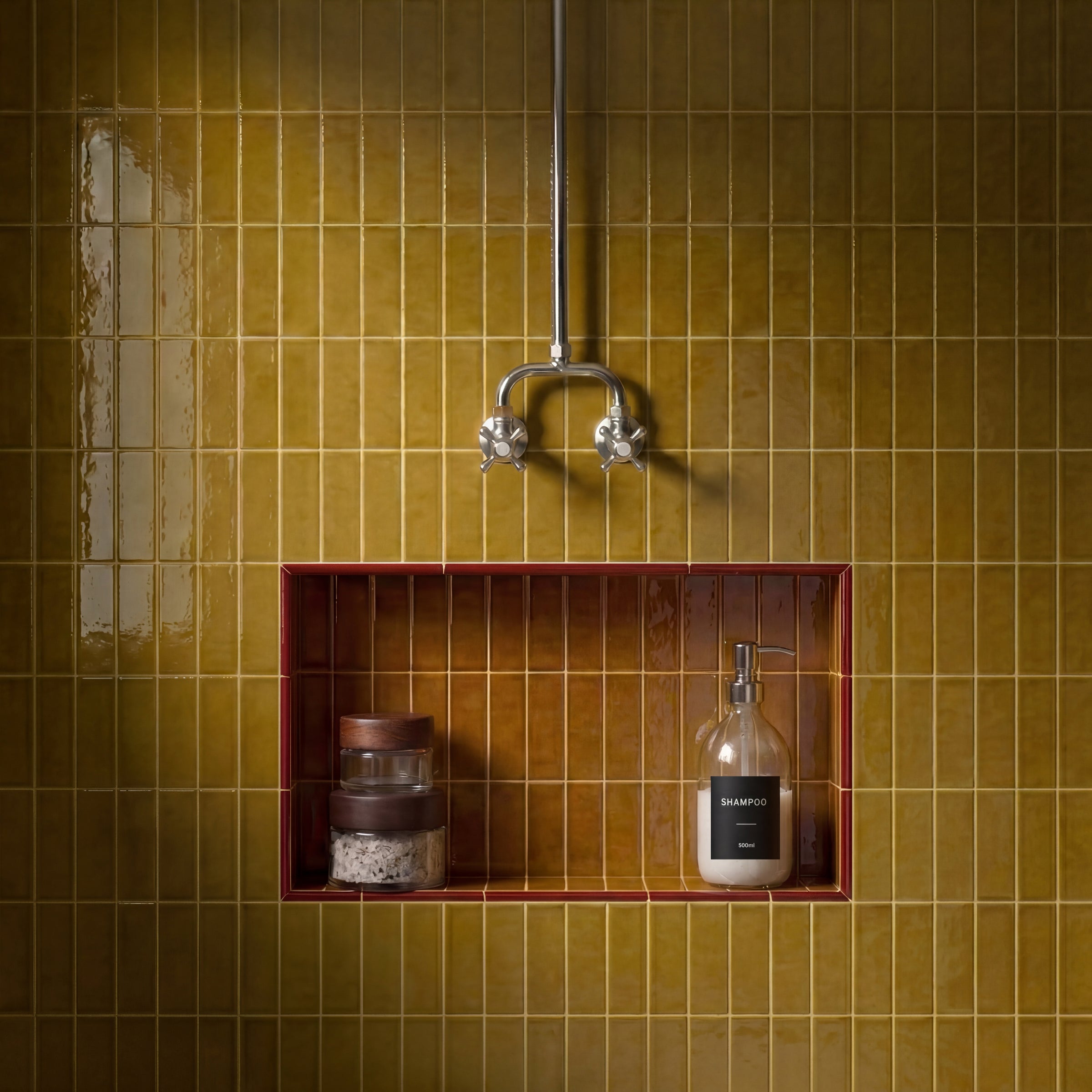 Glossy honey-colored ceramic tile wall with a recessed niche framed in red holding toiletries in a bathroom setting
