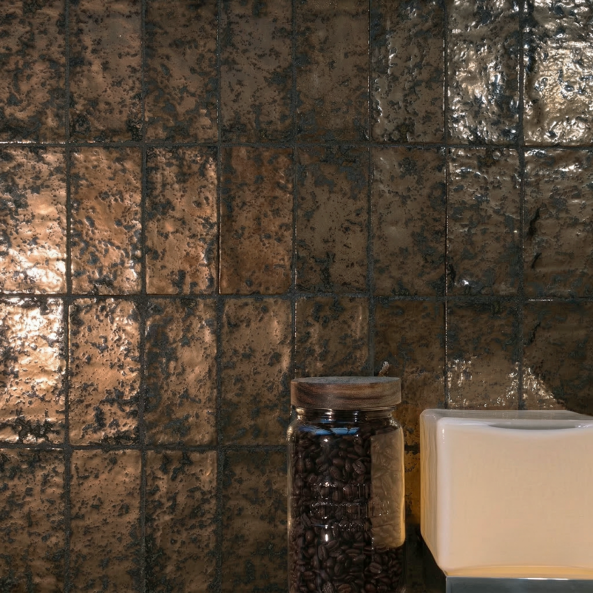 Glossy bronze-toned porcelain tiles with rich texture arranged in vertical rows behind jars on a countertop surface