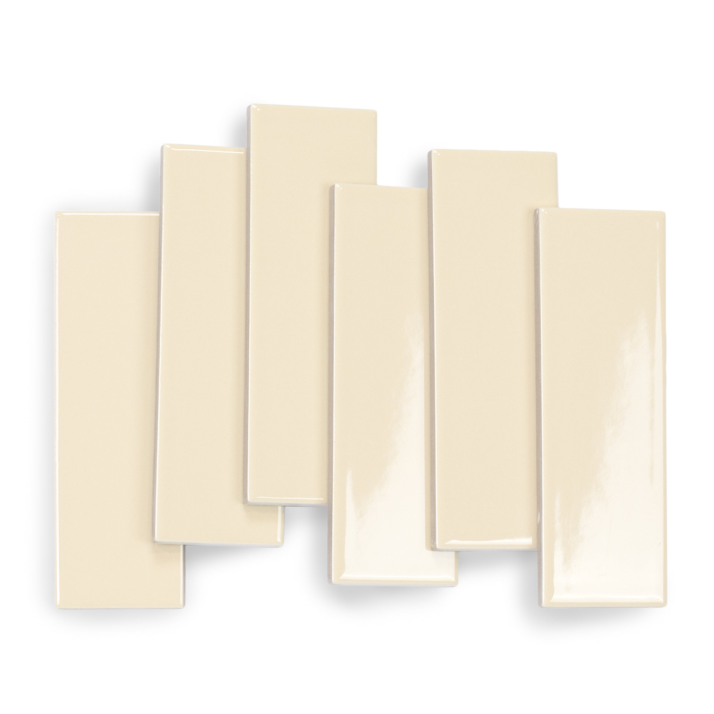 Glossy rectangular porcelain tiles in a soft champagne shade with smooth surfaces and softly rounded edges on white background