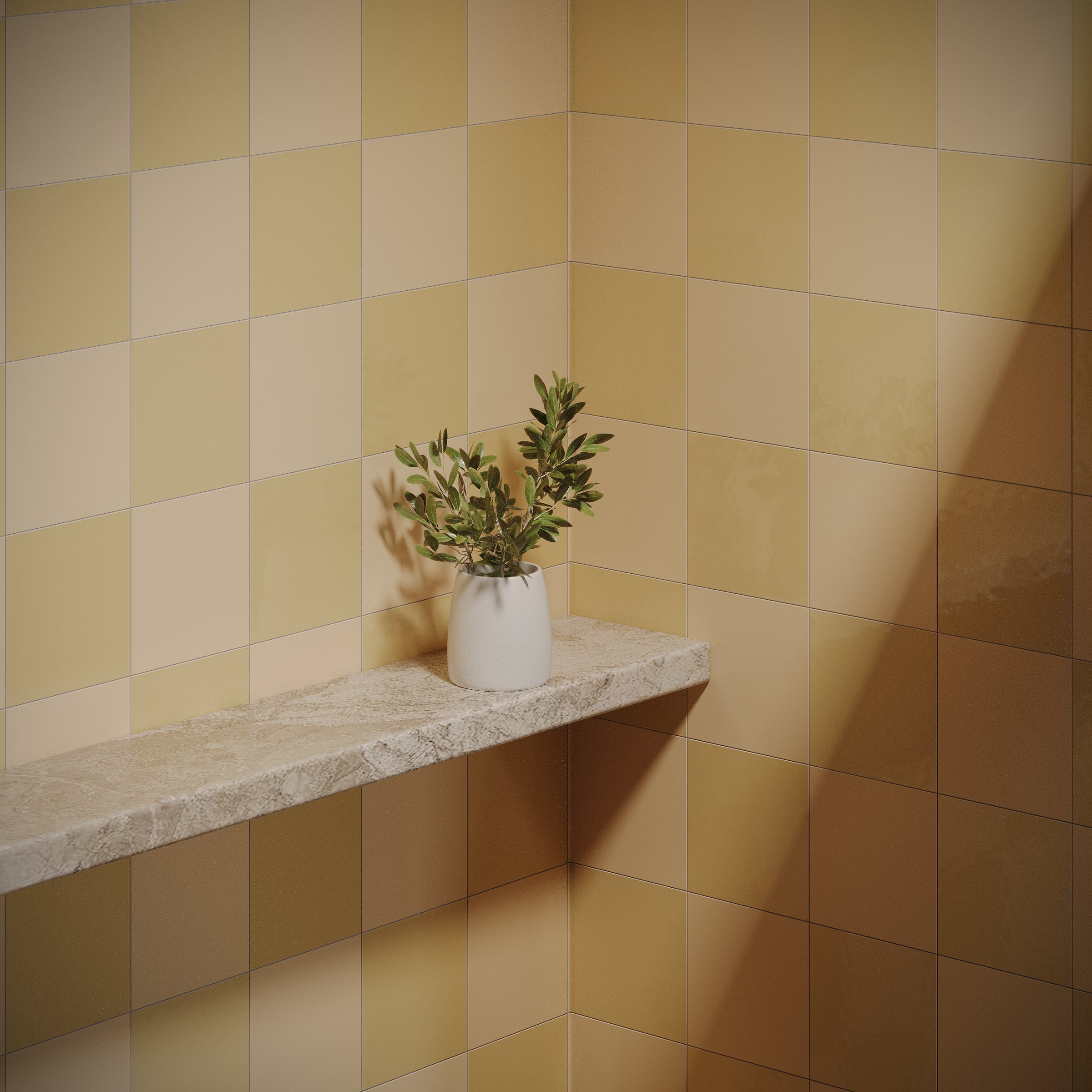 Matte porcelain tiles in warm champagne and mustard tones on walls with a stone shelf holding a small potted plant