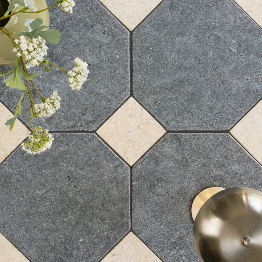 Large grey octagonal ceramic tiles with small cream square tiles arranged in a geometric pattern with white flowers nearby