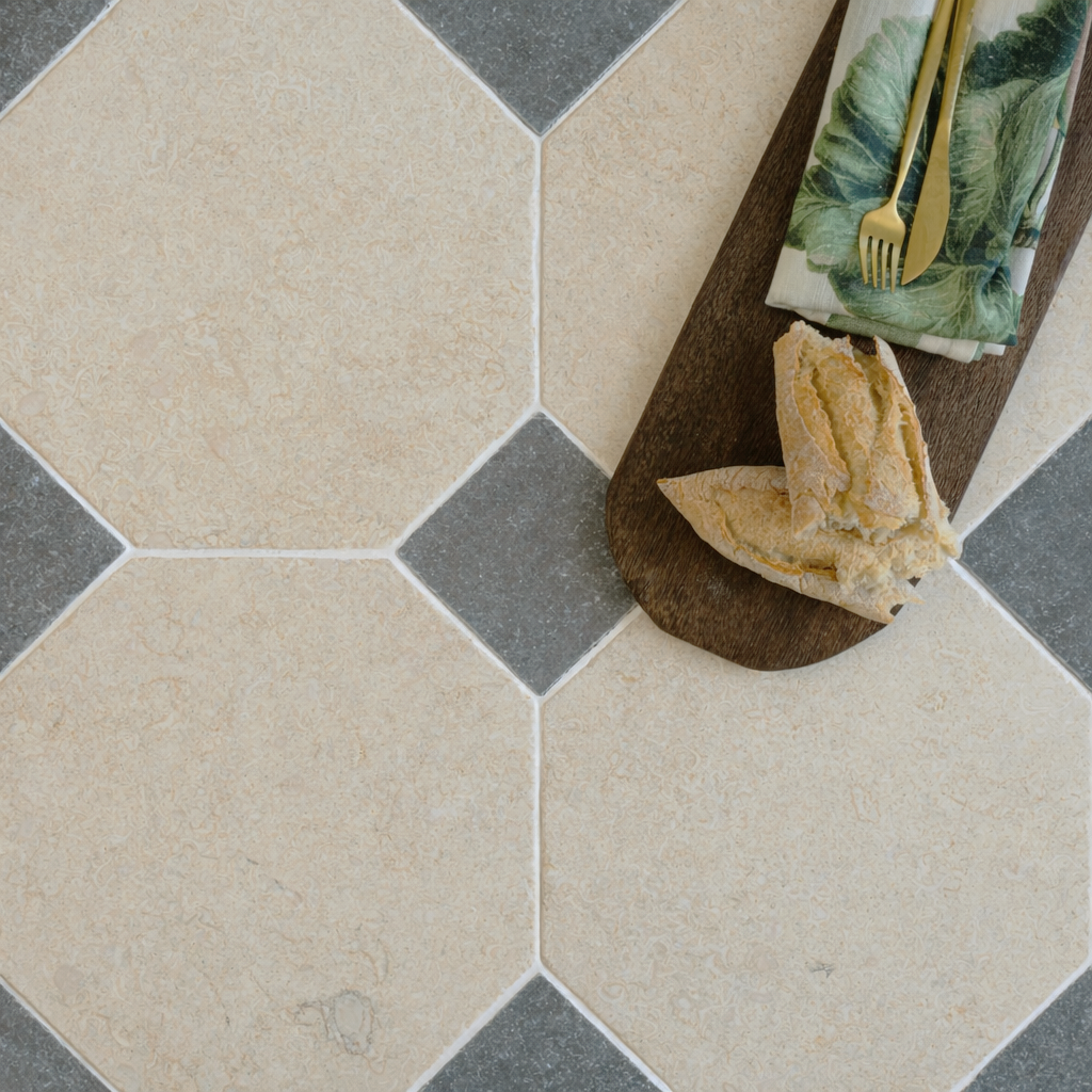 Large octagonal beige ceramic tiles with small grey square tiles arranged in a geometric pattern with a wooden board.