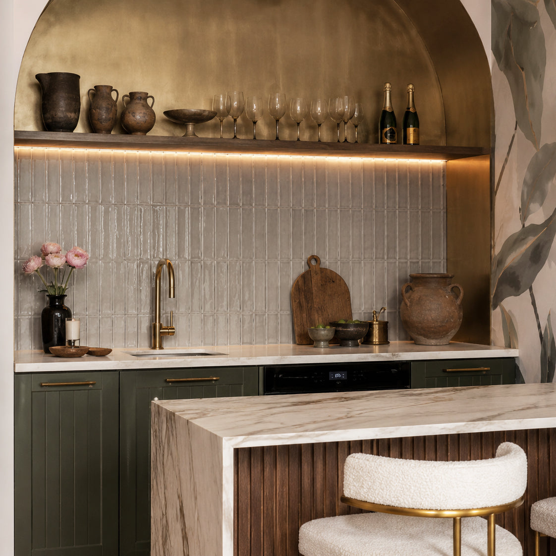 Modern kitchen with a gray tiled backsplash, dark cabinetry, marble island, and curved bar stools